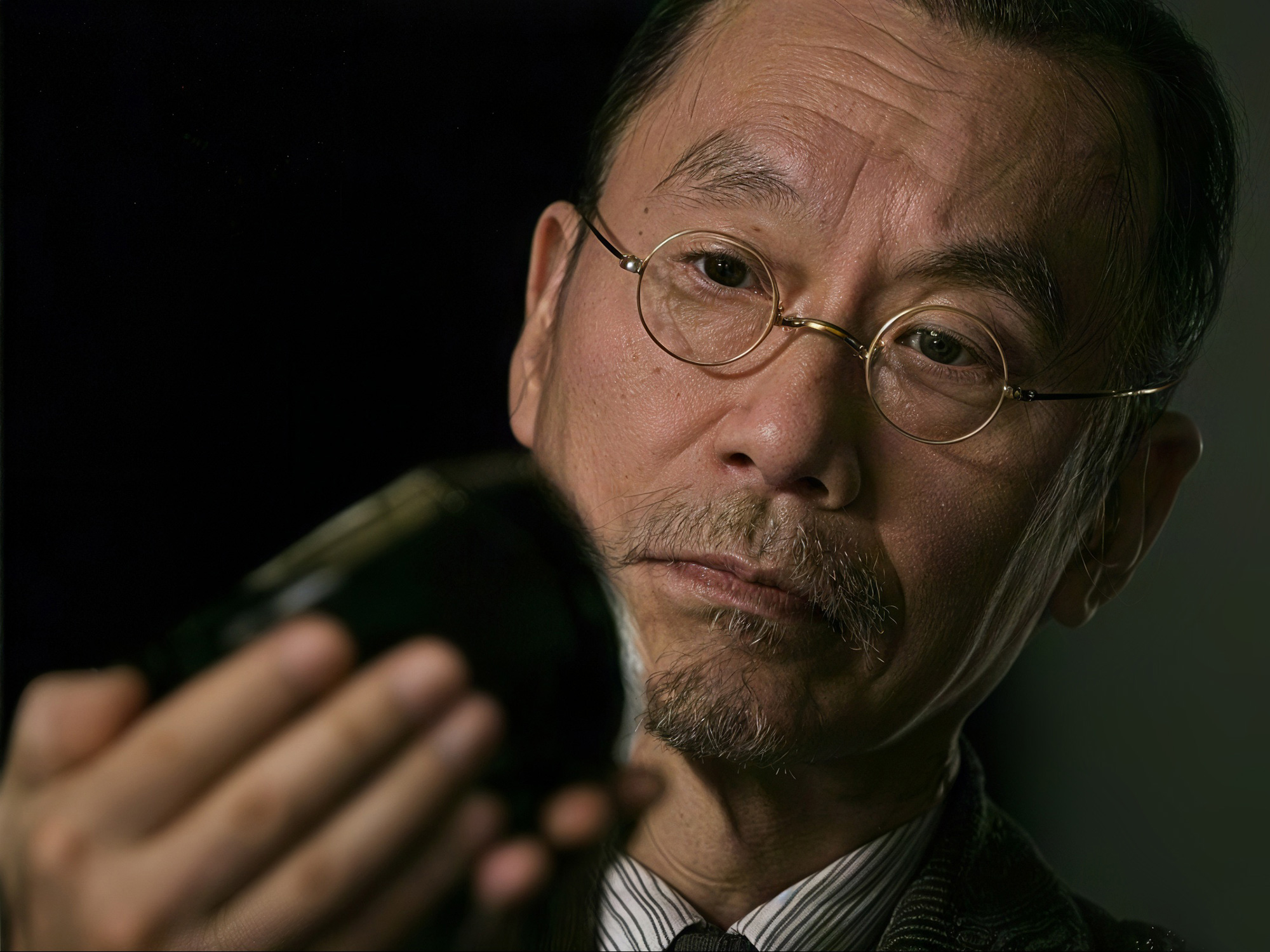 Close-up of Raku XV inspecting a hand-crafted ceramic piece, focusing on its form and finish.