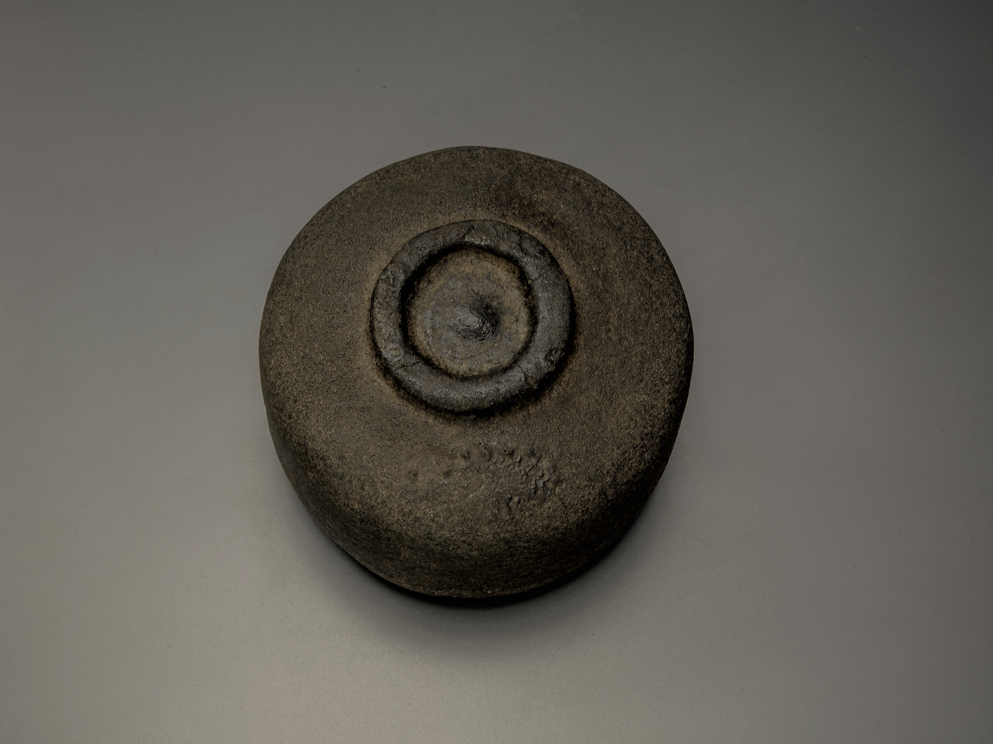 Foot (kōdai) of Chōjirō’s Raku tea bowl Musashino, showing the low circular base with hand-pressed...