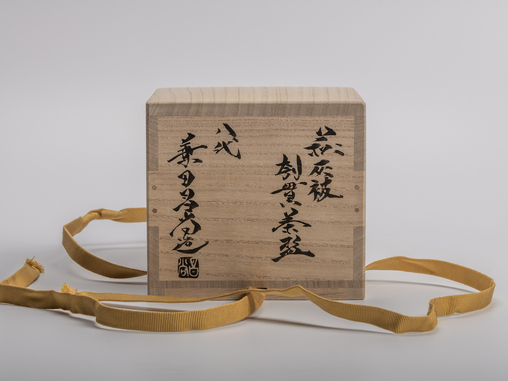 Wooden box (tomobako) for Masanao Kaneta’s Haikaburi Kurinuki tea bowl, shown with untied mustard...