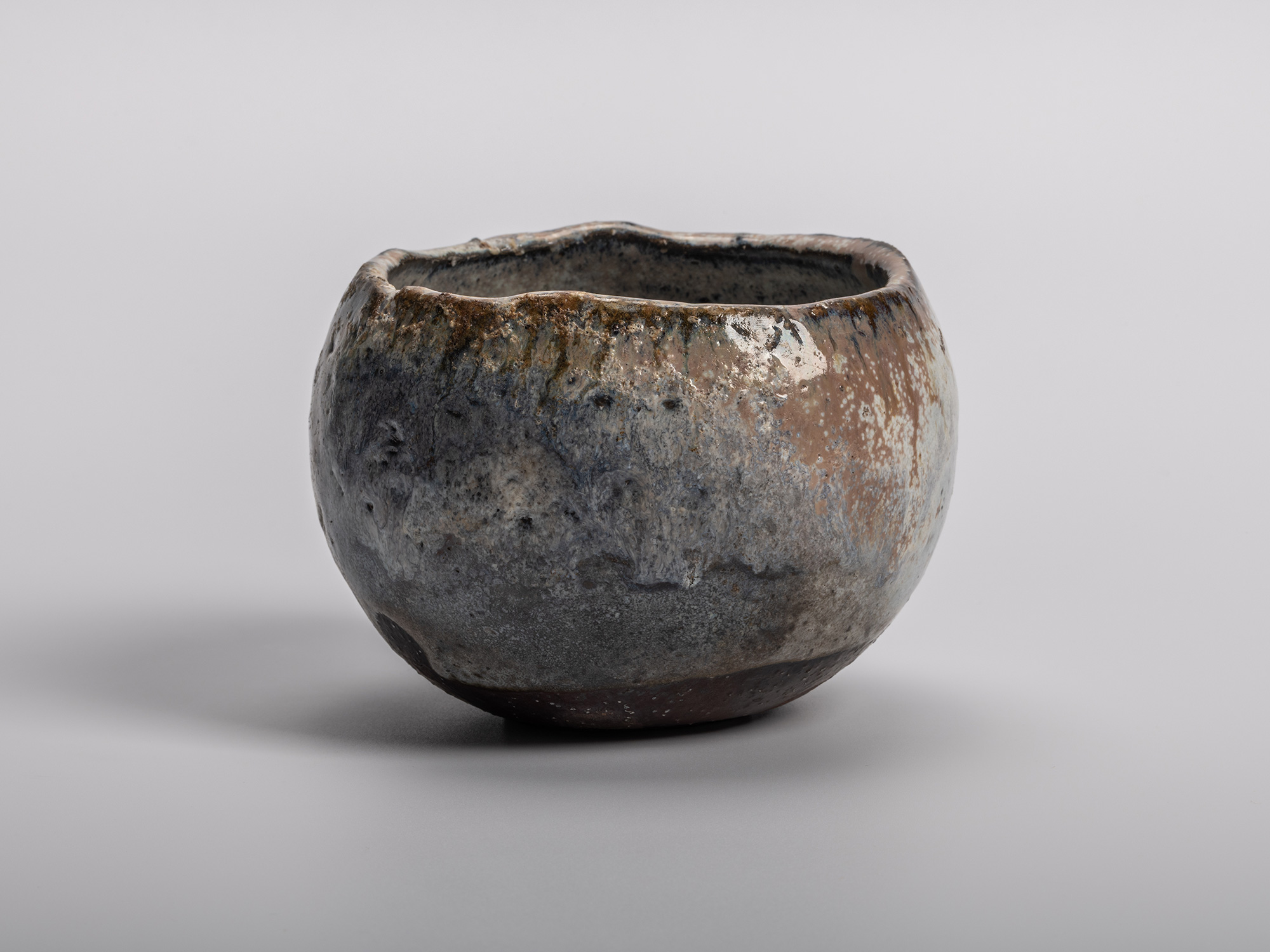 Masanao KANETA's Haikaburi Kurinuki Tea Bowl characterized by a rounded hand-carved form and mottled...