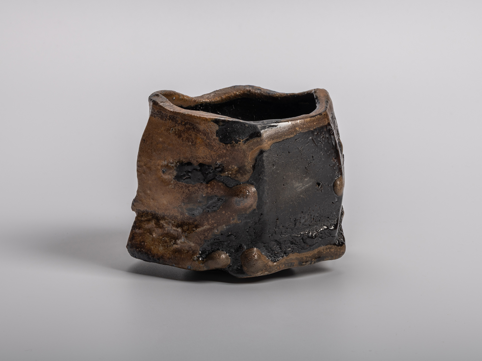A dramatic, dark-glazed Chamfered Tea Bowl (Tōl Wan) by Bizen ceramic artist Ryuichi Kakurezaki....