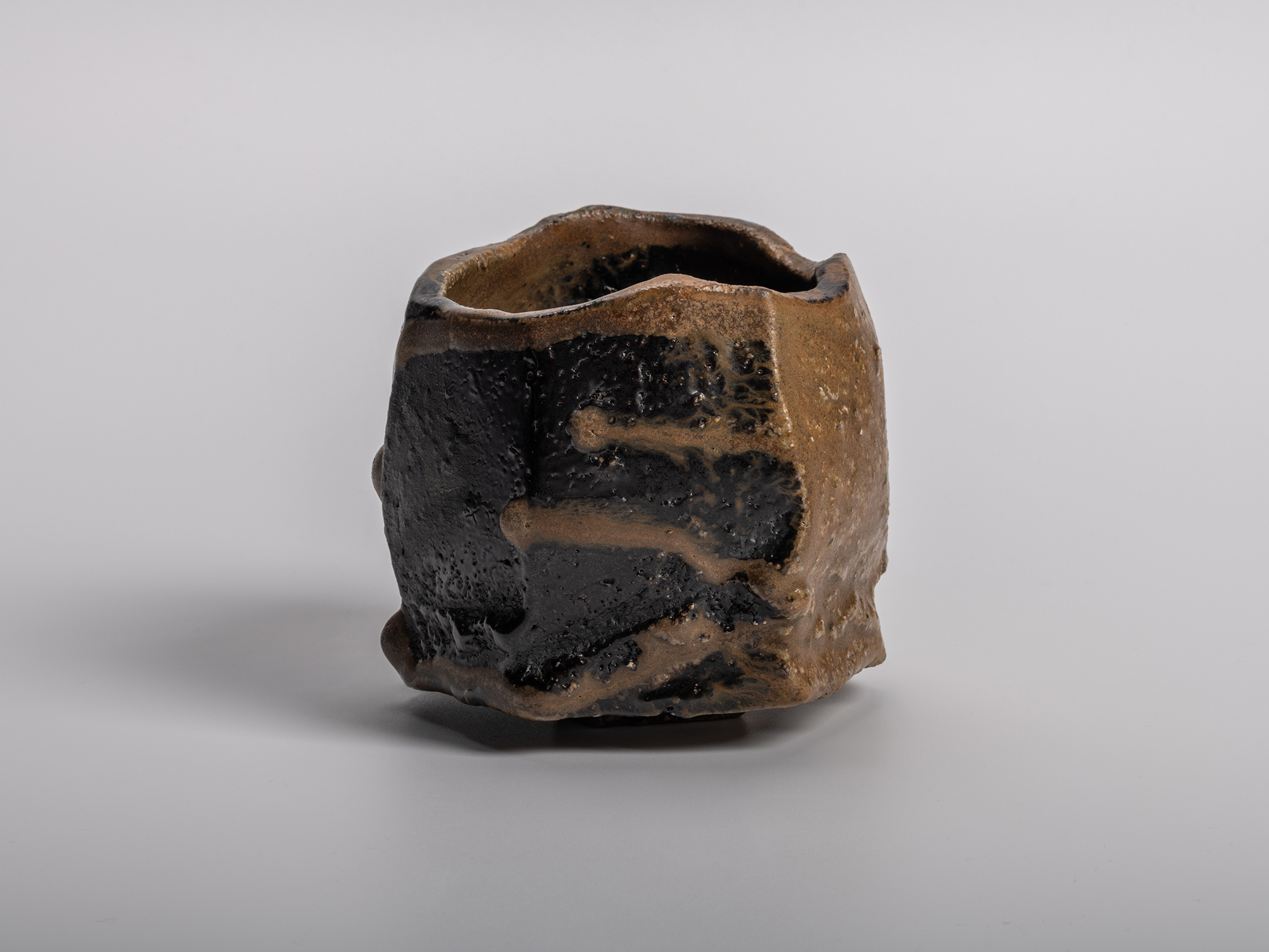 A dramatic, dark-glazed Chamfered Tea Bowl (Tōl Wan) by Bizen ceramic artist Ryuichi Kakurezaki....