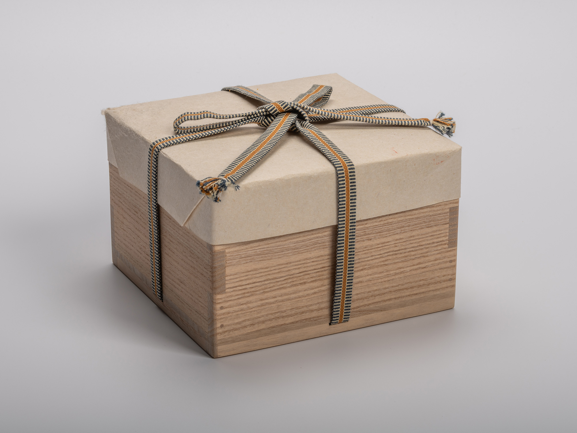 Square wooden tomobako (artist-signed storage box) by ceramic artist, shown with its gold and black...