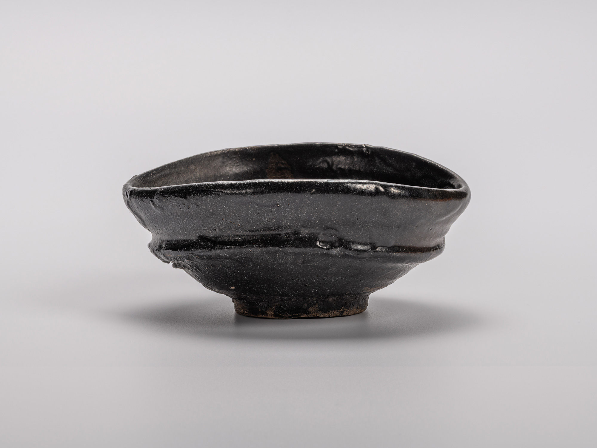 Oribe Kuro Chawan by Shiro Tsujimura, a hand-formed black tea bowl with oval contours and a rich,...
