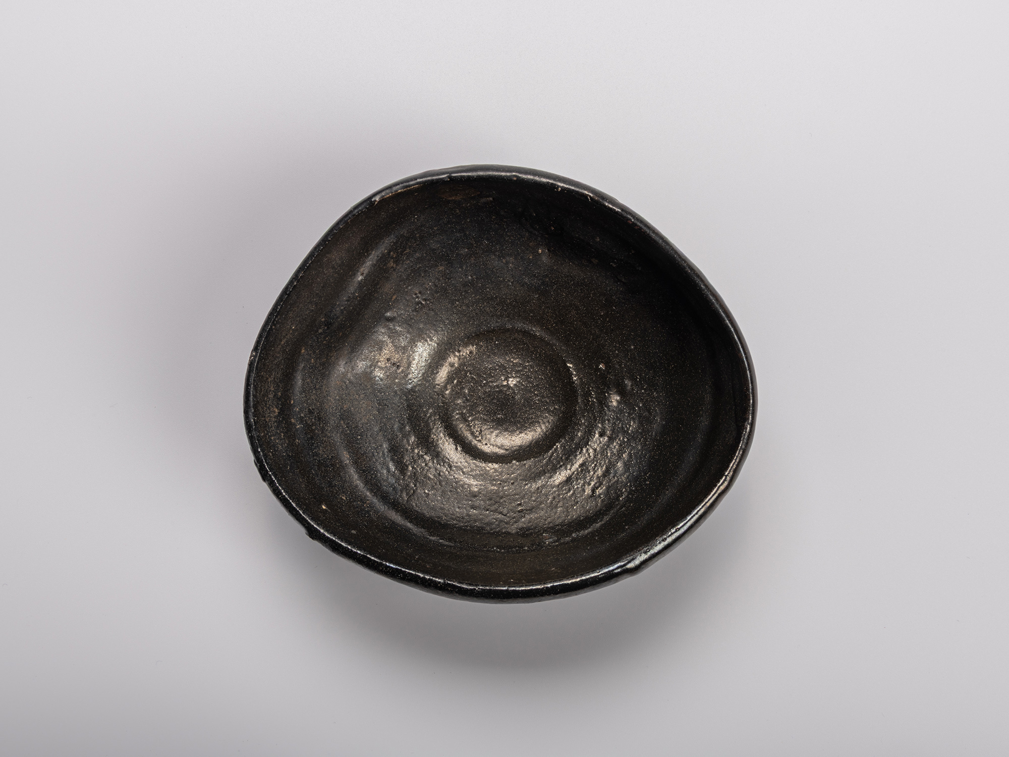 Interior (mikomi) of Shiro Tsujimura’s Oribe Kuro Chawan, showing the hand-formed black glaze surface...