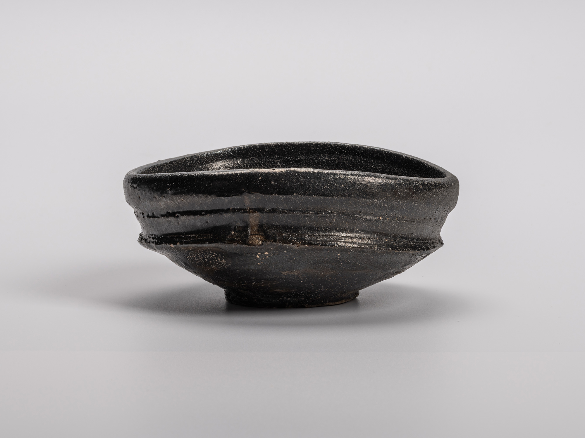 Oribe Kuro Chawan by Shiro Tsujimura, a hand-formed black tea bowl with layered glaze textures...