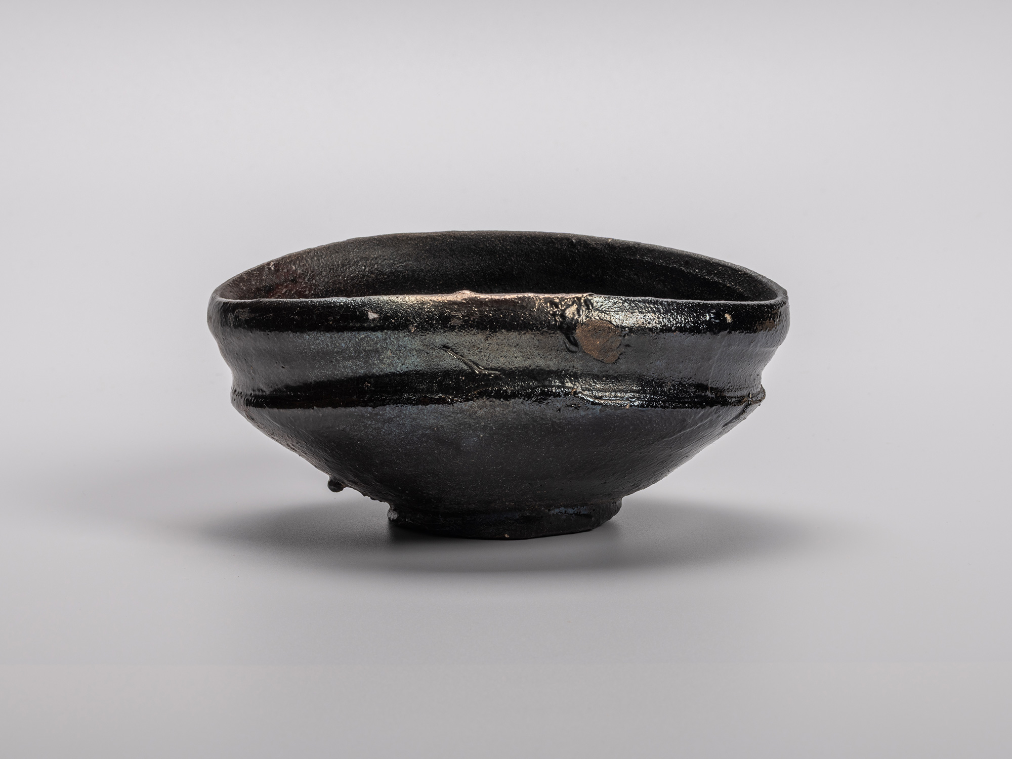 Oribe Kuro Chawan by Shiro Tsujimura, a hand-shaped black tea bowl featuring subtle distortions,...