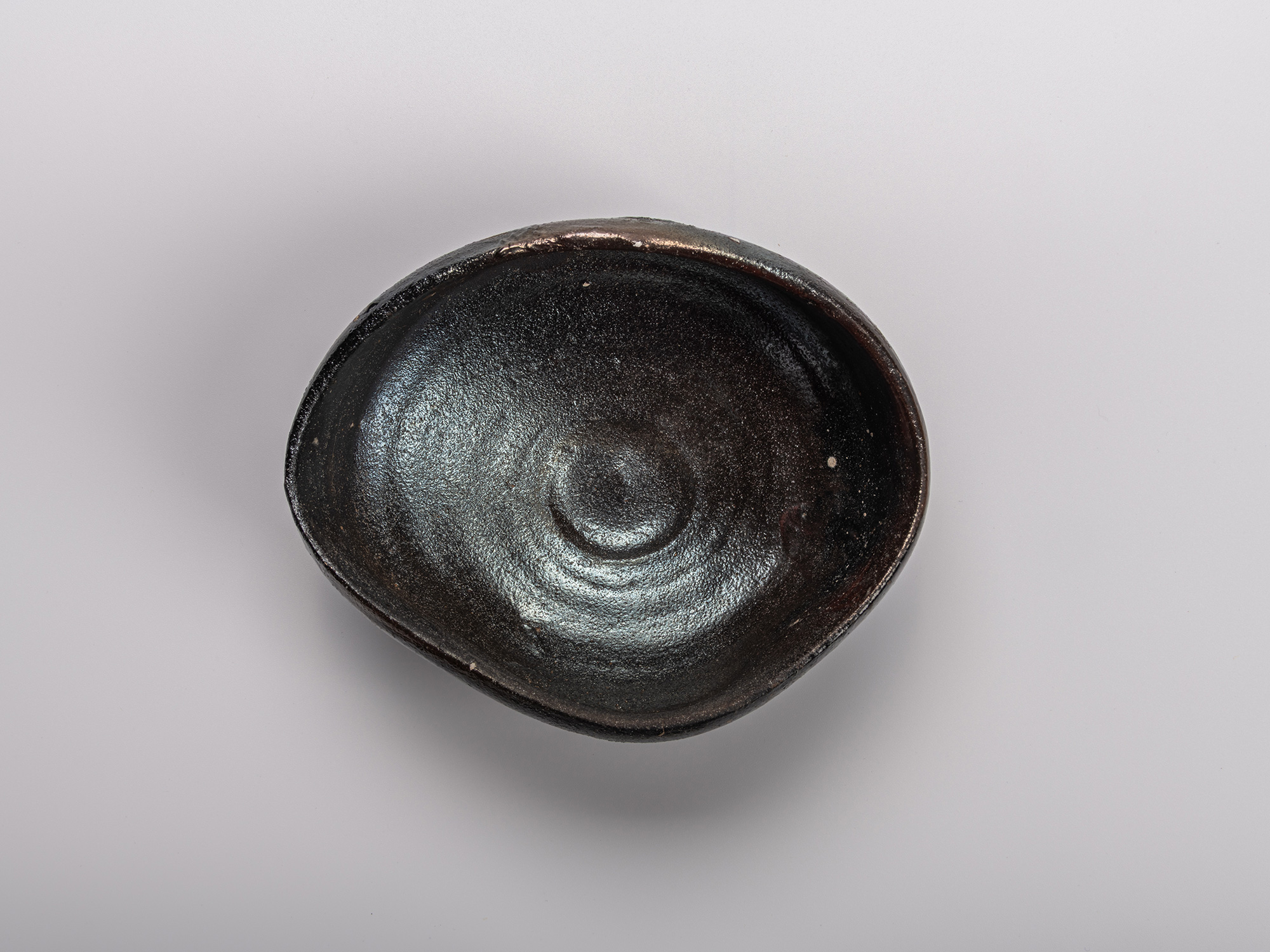 Interior (mikomi) of Shiro Tsujimura’s Oribe Kuro Chawan, showing the hand-formed black glaze surface...
