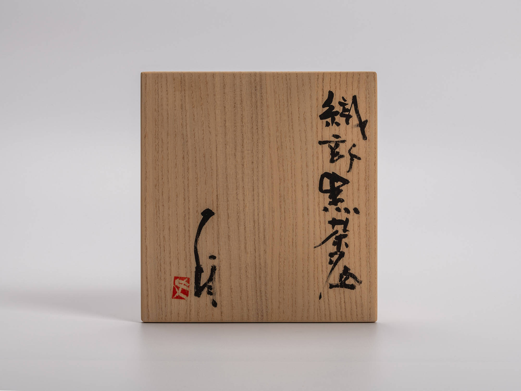Wooden storage box lid for Shiro Tsujimura’s Oribe Kuro Chawan, inscribed with calligraphy reading...