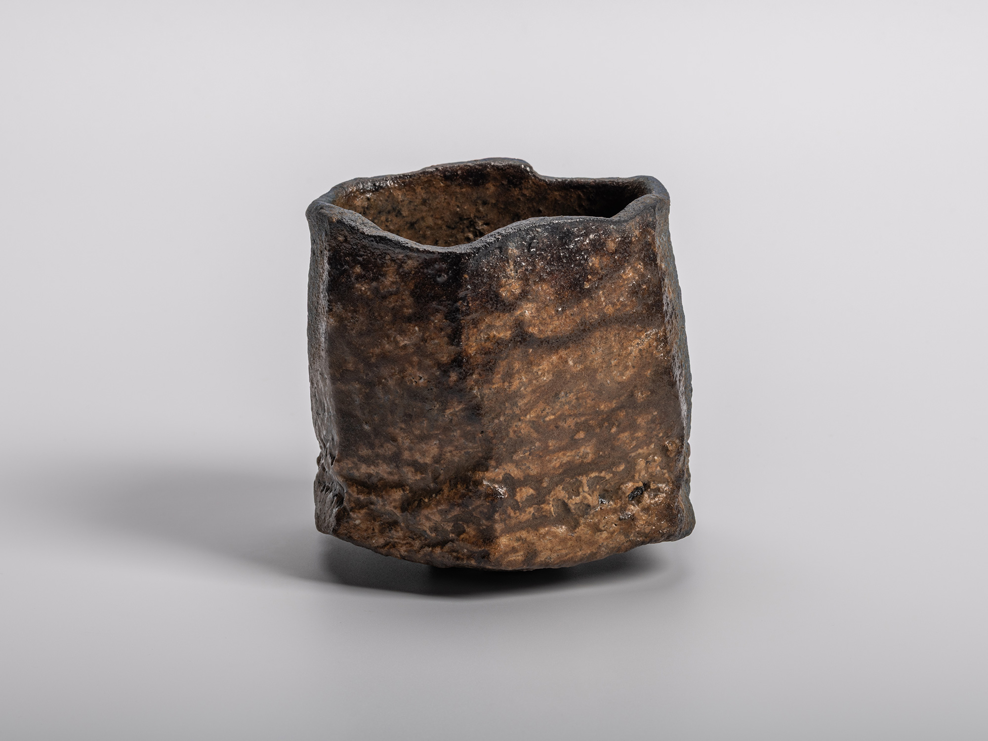 Kakurezaki Ryuichi tea bowl Una Mistura showing its sculptural square form with textured blue-to-earth-toned...