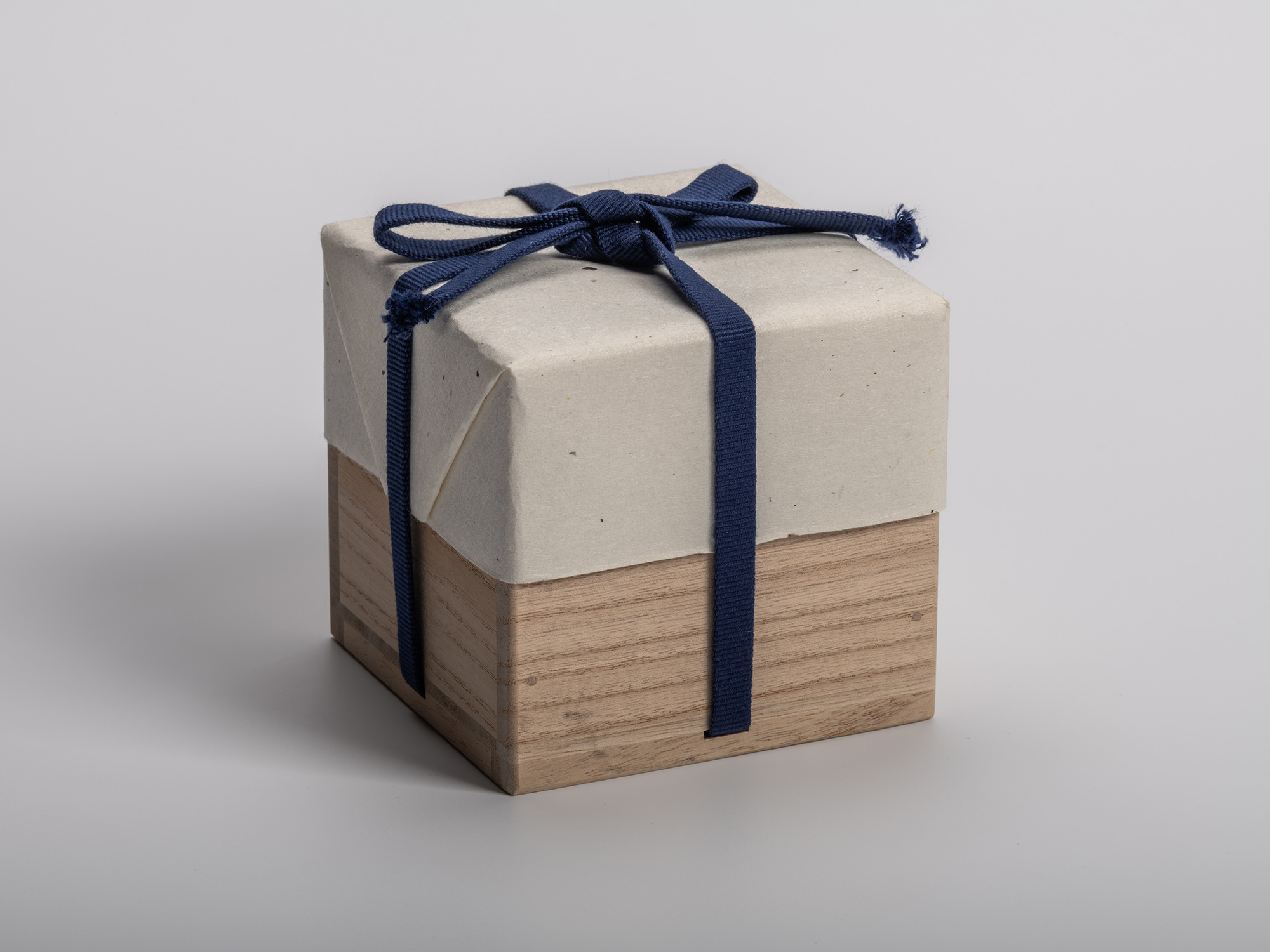Square wooden tomobako (artist-signed storage box) by ceramic artist, shown with its navy-blue...