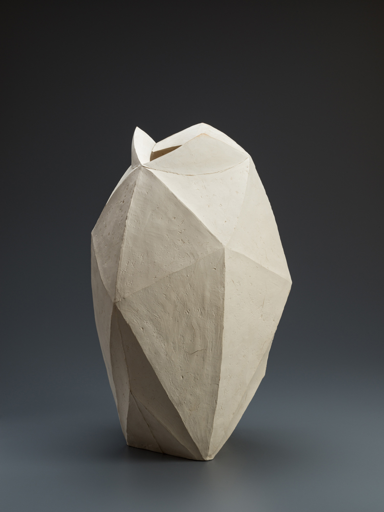 White multifaceted ceramic vase by Mori Tōgaku with sharply folded, paper-like planes and a matte...