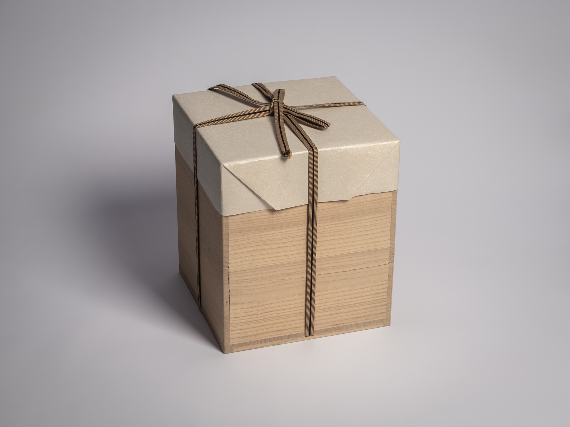 Square wooden tomobako (artist-signed storage box) by ceramic artist, shown with its brown cloth...