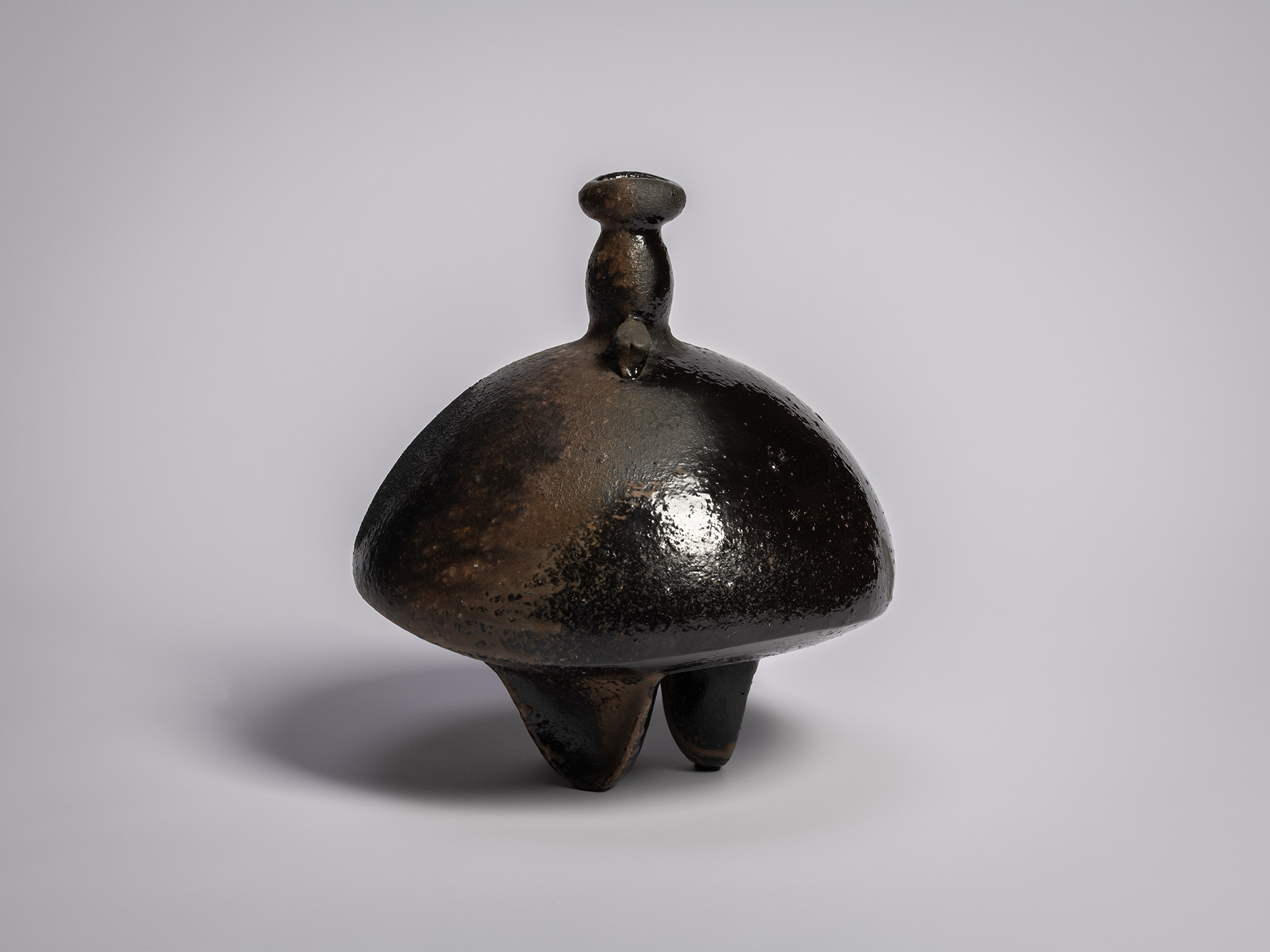Black glazed sculptural ceramic vessel by Ryuichi Kakurezaki, featuring a bulbous domed body, small...