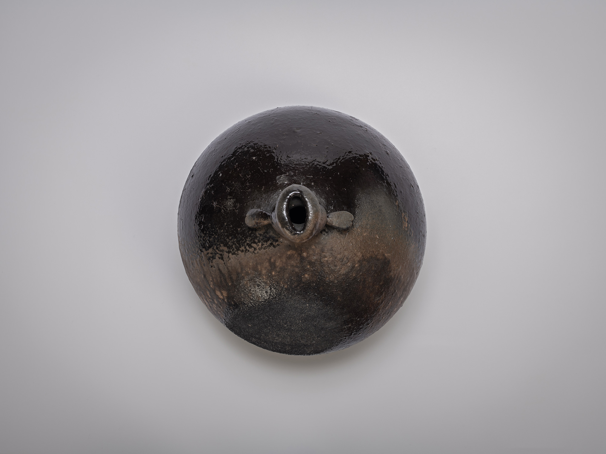 Aerial view of black glazed sculptural ceramic vessel by Ryuichi Kakurezaki, featuring a bulbous...