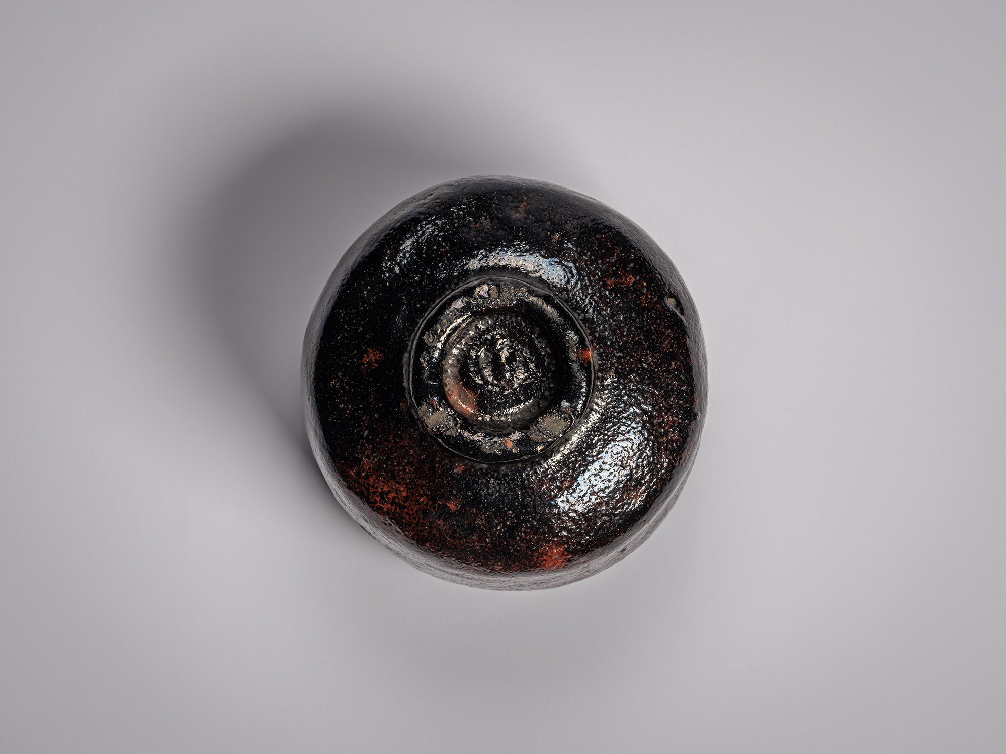 Foot (kōdai) of a Black Raku tea bowl by Raku Ichinyū IV, showing a hand-trimmed circular base...