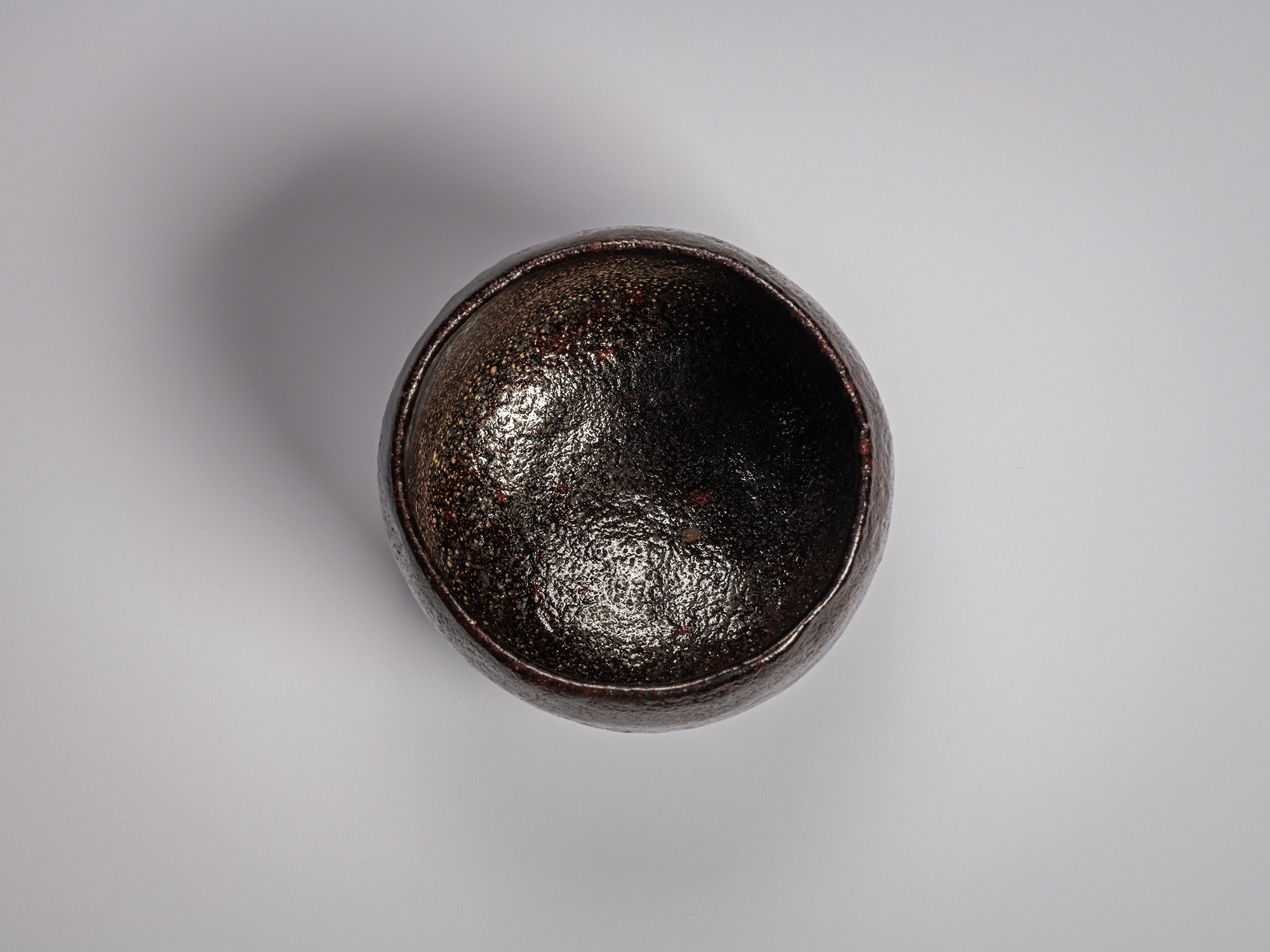 Interior (mikomi) of a Black Raku tea bowl by Raku Ichinyū IV, showing a dark, subtly metallic...