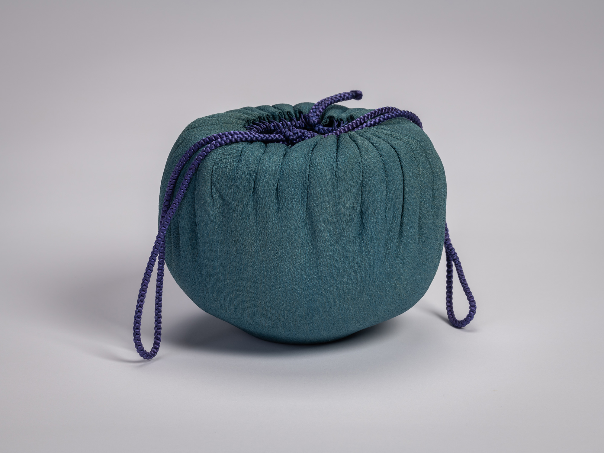 Black Raku tea bowl by Raku IV (Ichinyū) enclosed in a traditional protective shifuku satchel,...