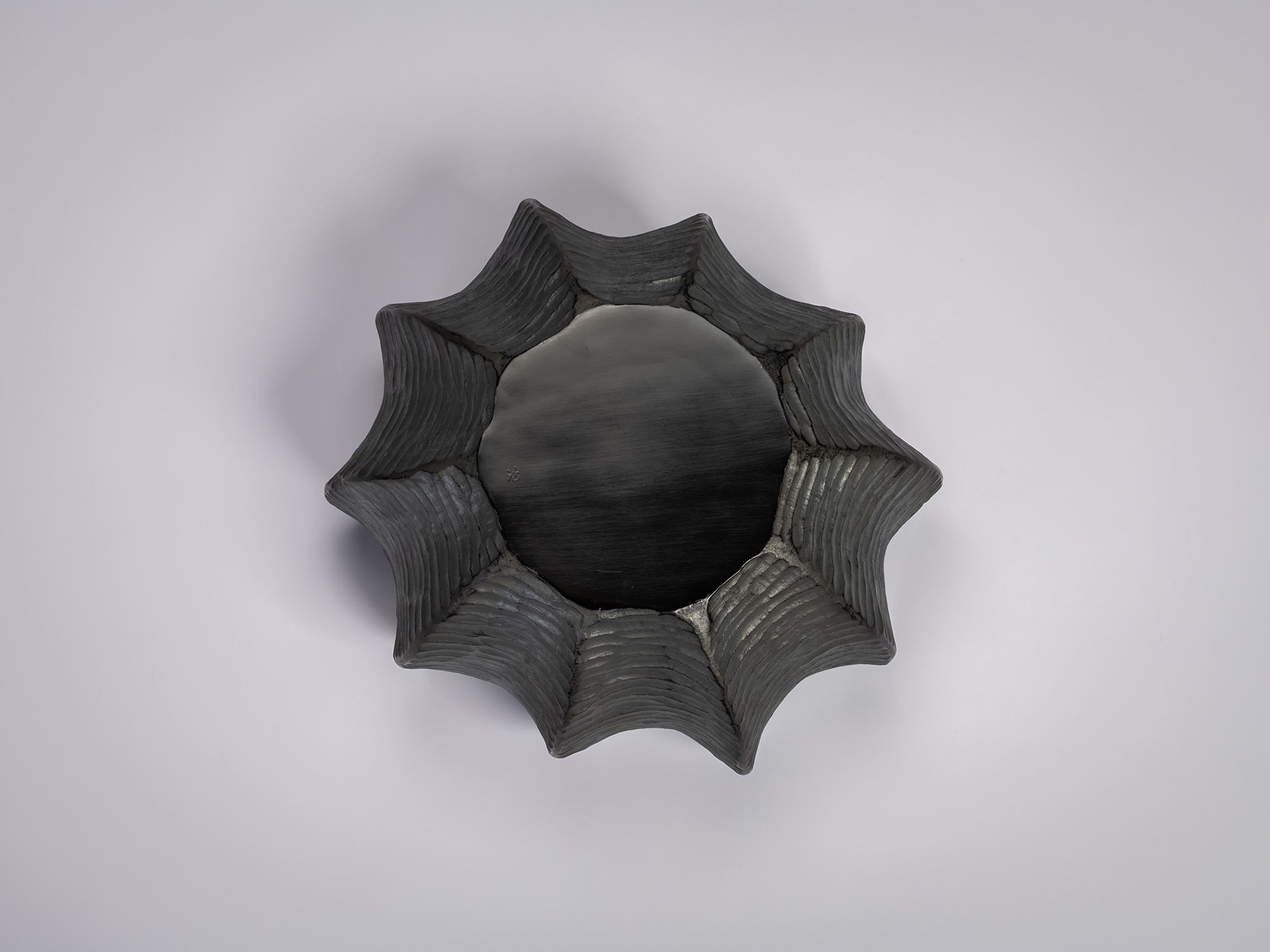 Underside view of the foot of the Furrowed Black Zelkova Water Jar by Jihei Murase, showing a circular...