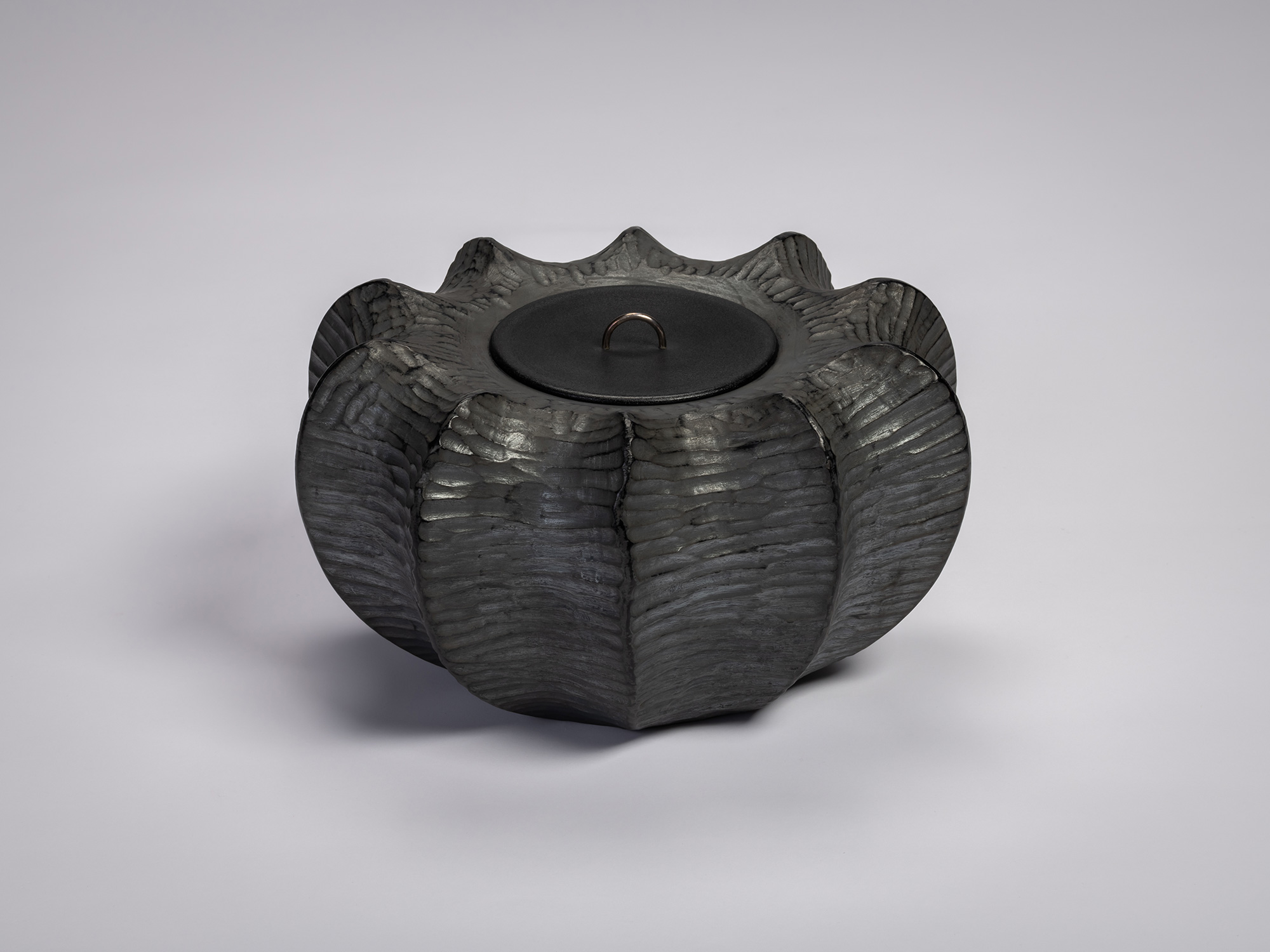 Front view of the Furrowed Black Zelkova Water Jar by Jihei Murase, a lacquered vessel with a sculptural,...