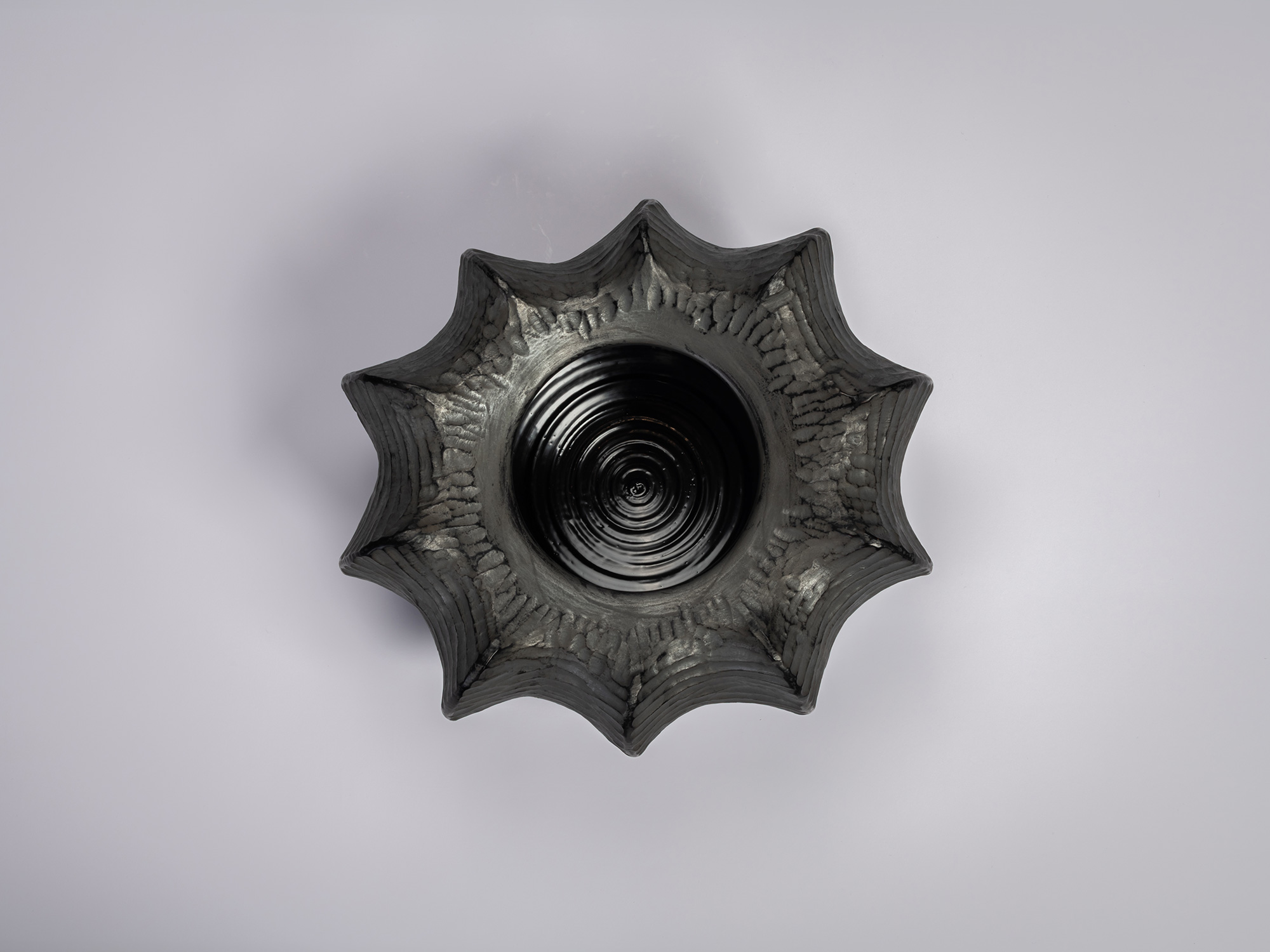 Aerial view of the Furrowed Black Zelkova Water Jar by Jihei Murase, a lacquered vessel with a...