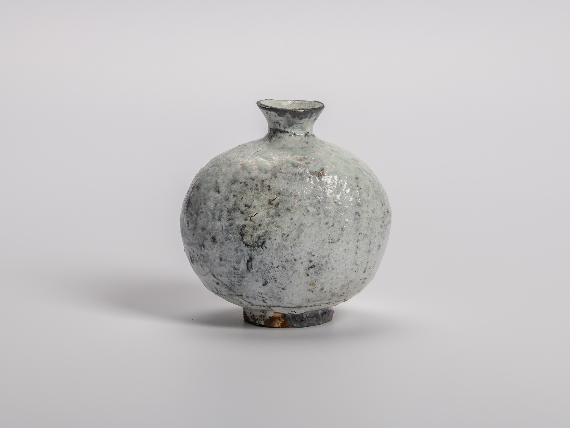 Haikaburi tokkuri (sake bottle) with a rounded, bulbous body and short flared neck, showing thick...
