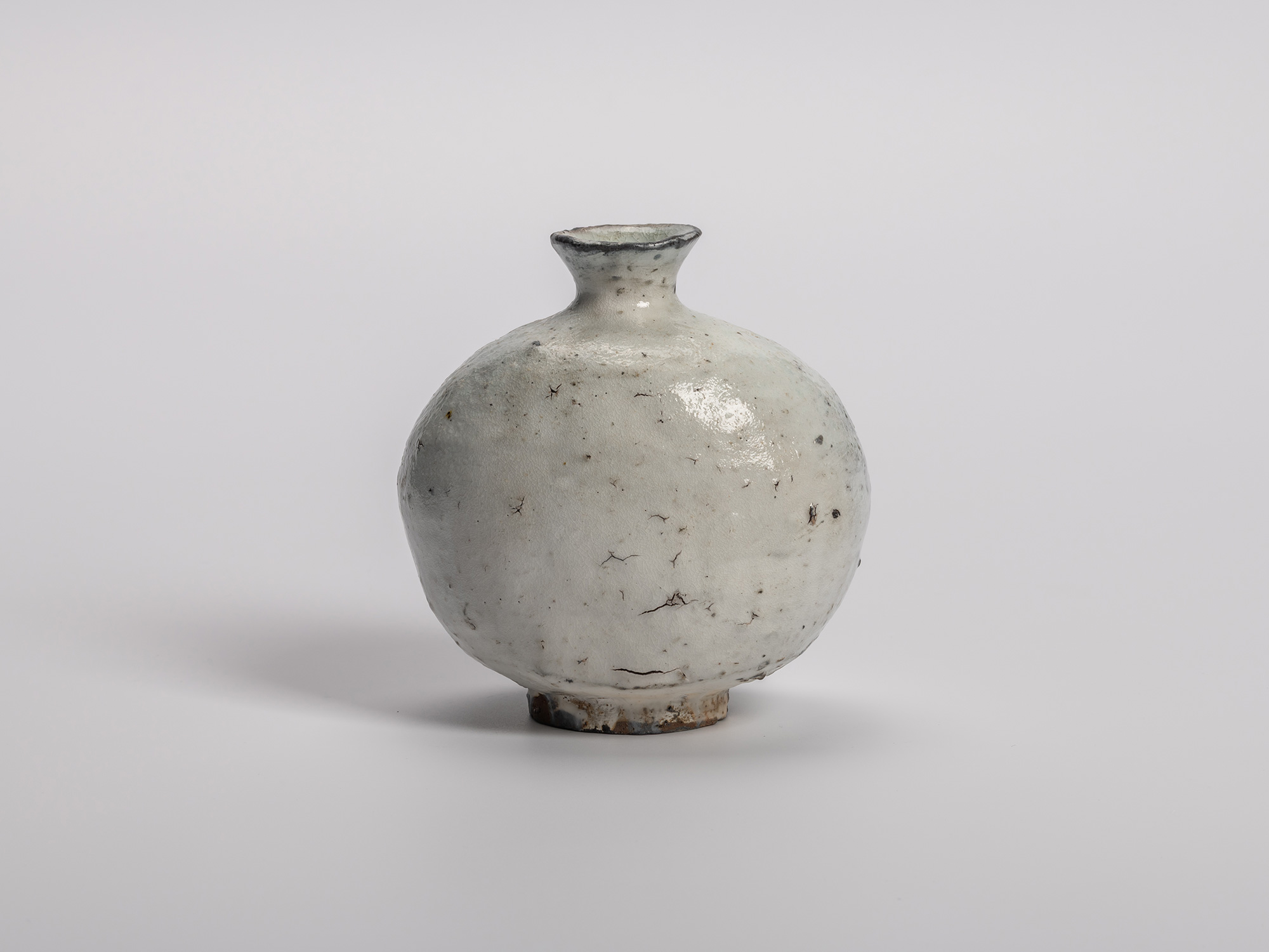 Haikaburi tokkuri (sake bottle) with a rounded, bulbous body and short flared neck, showing thick...