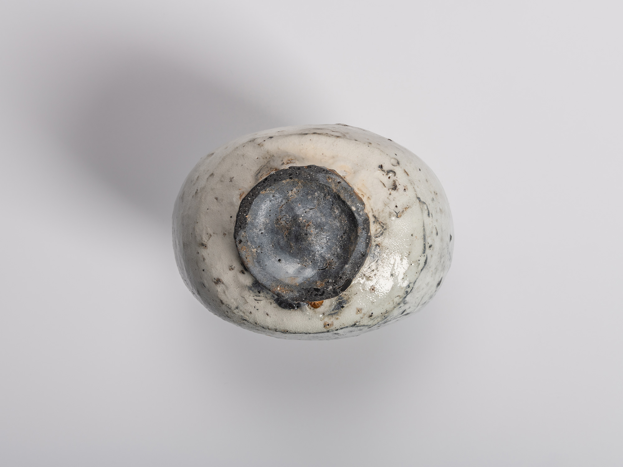 Bottom view of a haikaburi tokkuri (sake bottle), showing the circular foot ring with exposed dark...