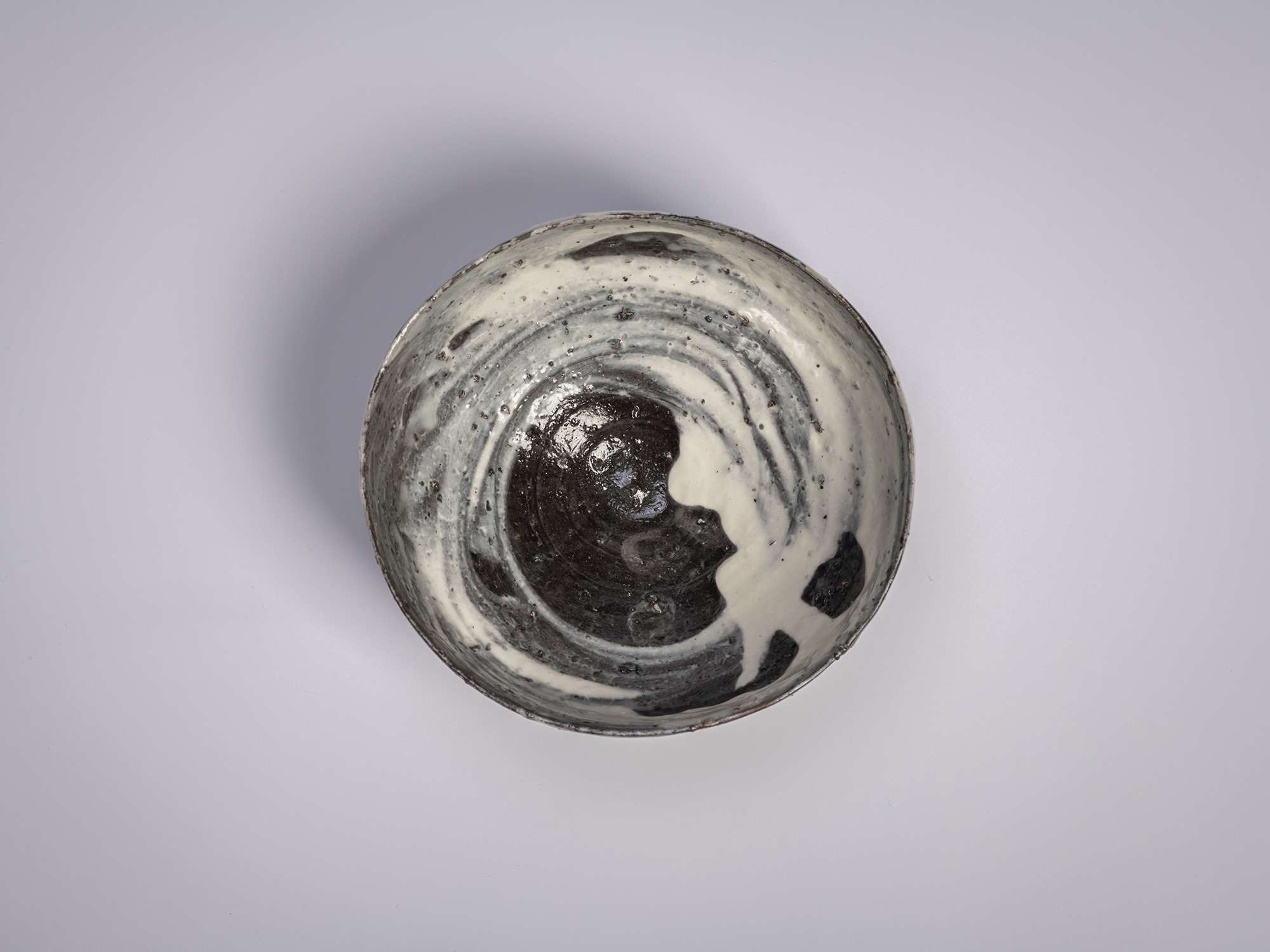 Interior (mikomi) of a Hakeme tea bowl by Shiro Tsujimura, showing swirling white slip brushwork...