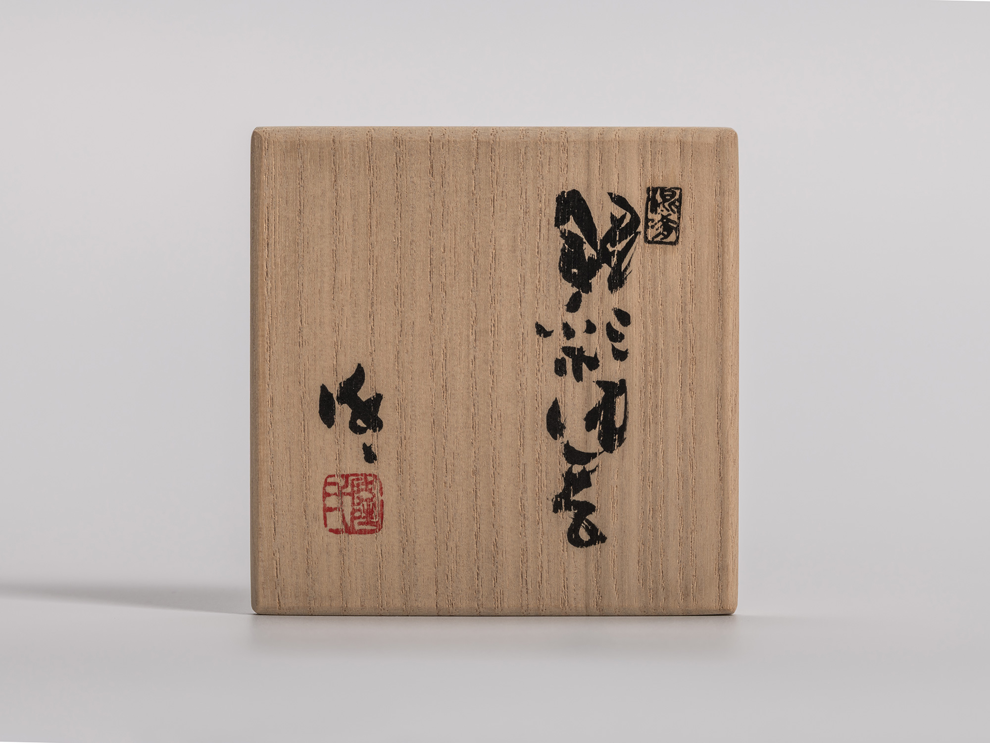 Wooden tomobako lid for an Iron Oribe (E-Oribe) sake cup by Kakurezaki Ryūichi, bearing an abbreviated...