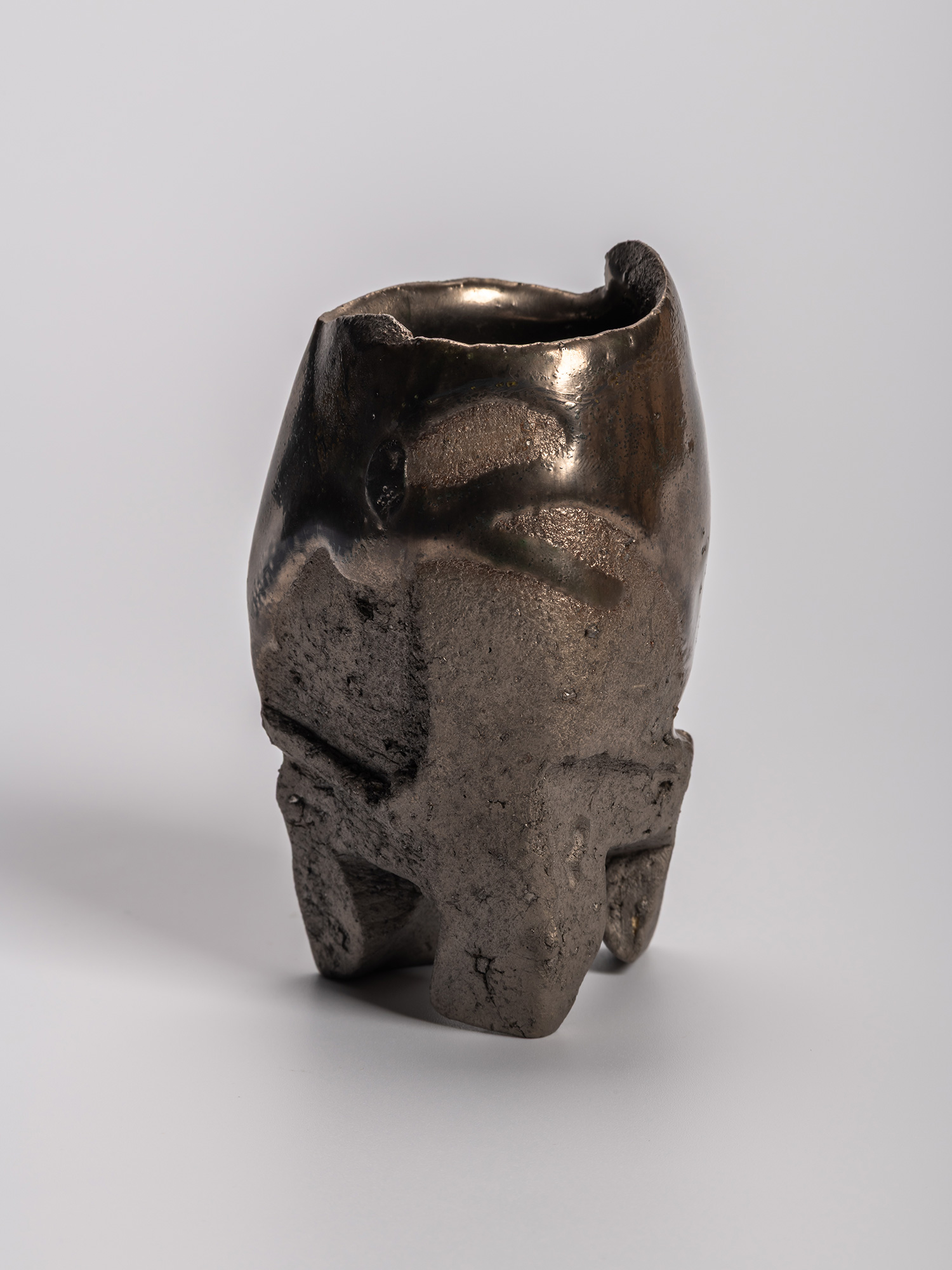 Gray-toned opaque Oribe sake cup with an irregular, sculptural form, subtly distorted rim, and...