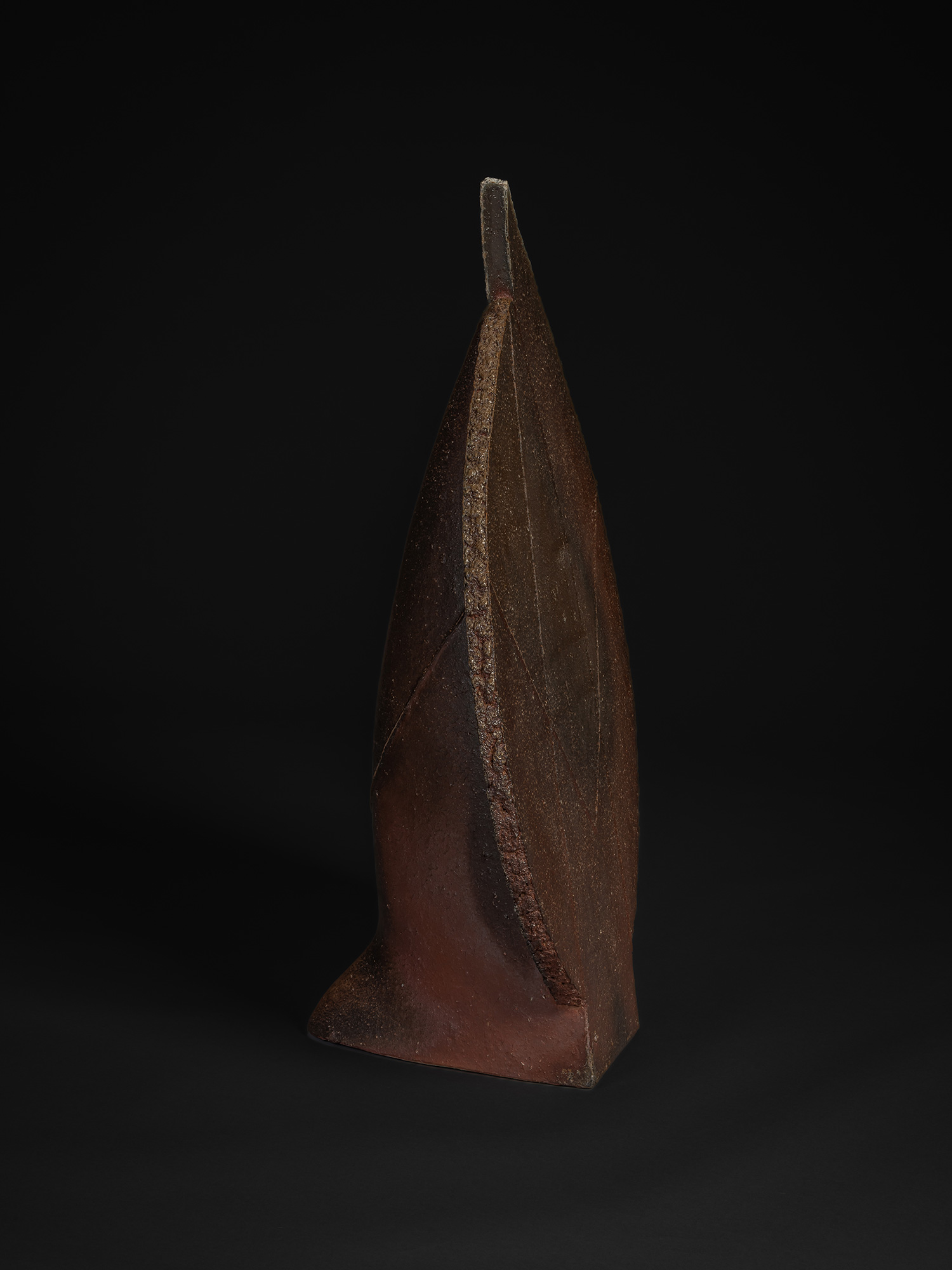 Profile view of Phalanx by Kakurezaki Ryūichi, vertical sculptural ceramic in Bizen clay with sharp...