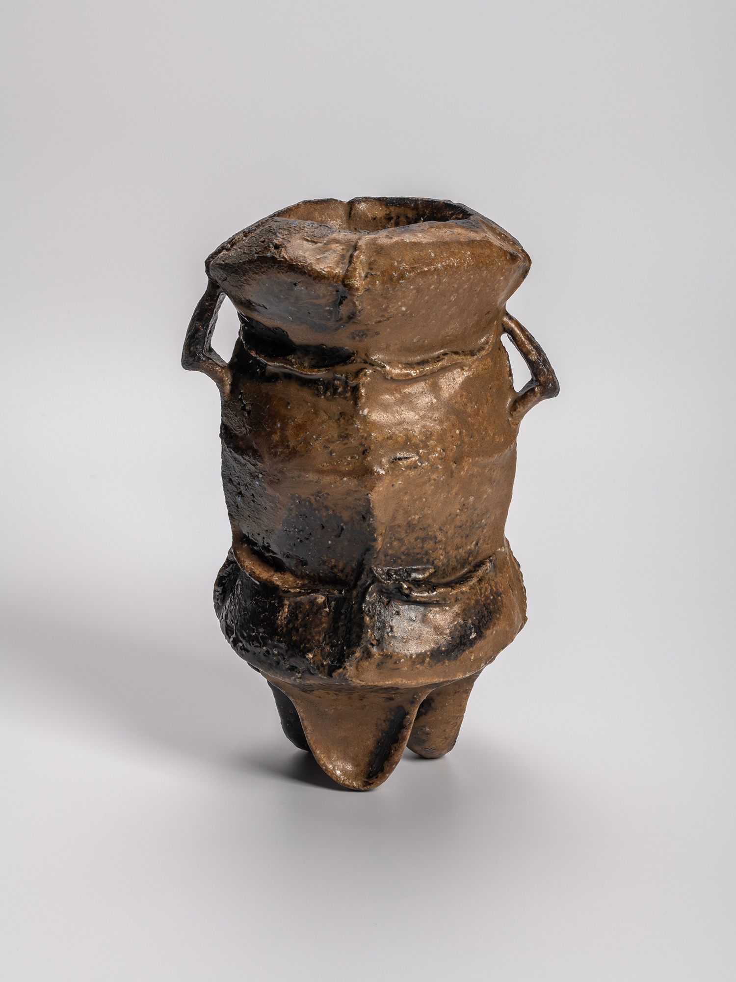 Black three-legged ceramic vase by Kakurezaki Ryūichi, featuring a rugged, sculptural form with...