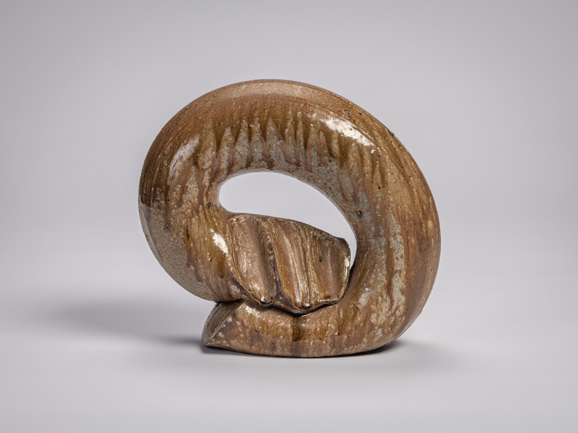 Front view of the ceramic sculpture Ring by Jun Isezaki, featuring a thick circular form with an...