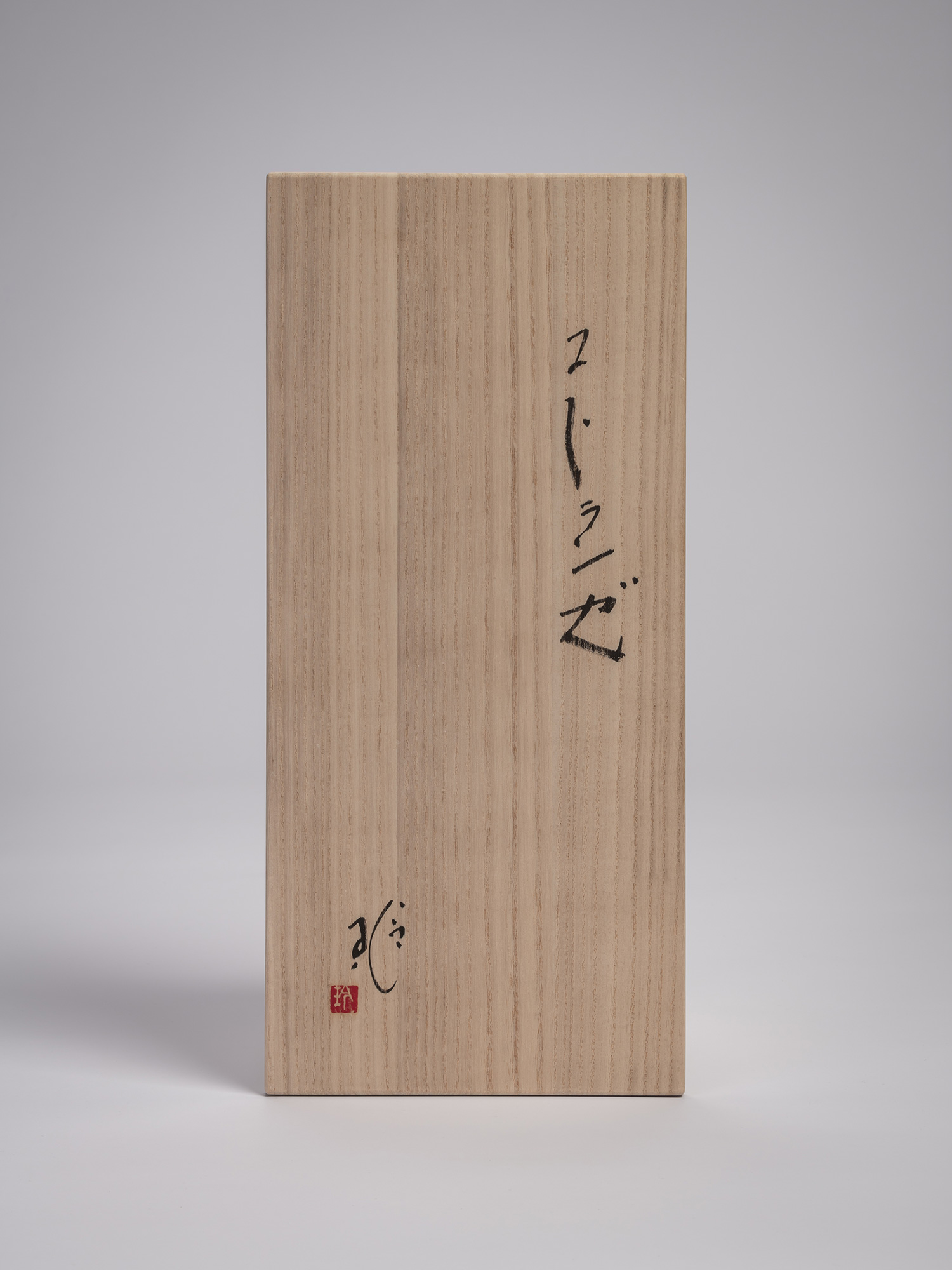 Wooden tomobako (storage box) lid for the iron sculpture Sai by Aki Rusu. Black calligraphy on...