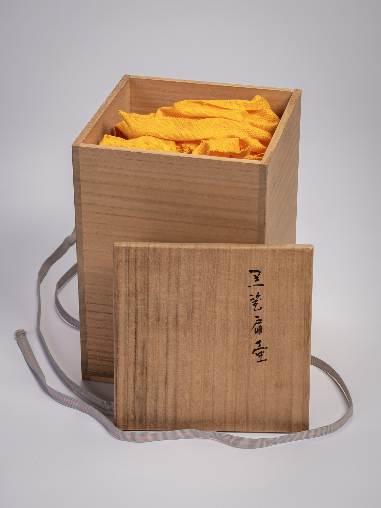 Wooden tomobako (storage box) containing a black stoneware rectangular jar by Mori Tōgaku, shown...