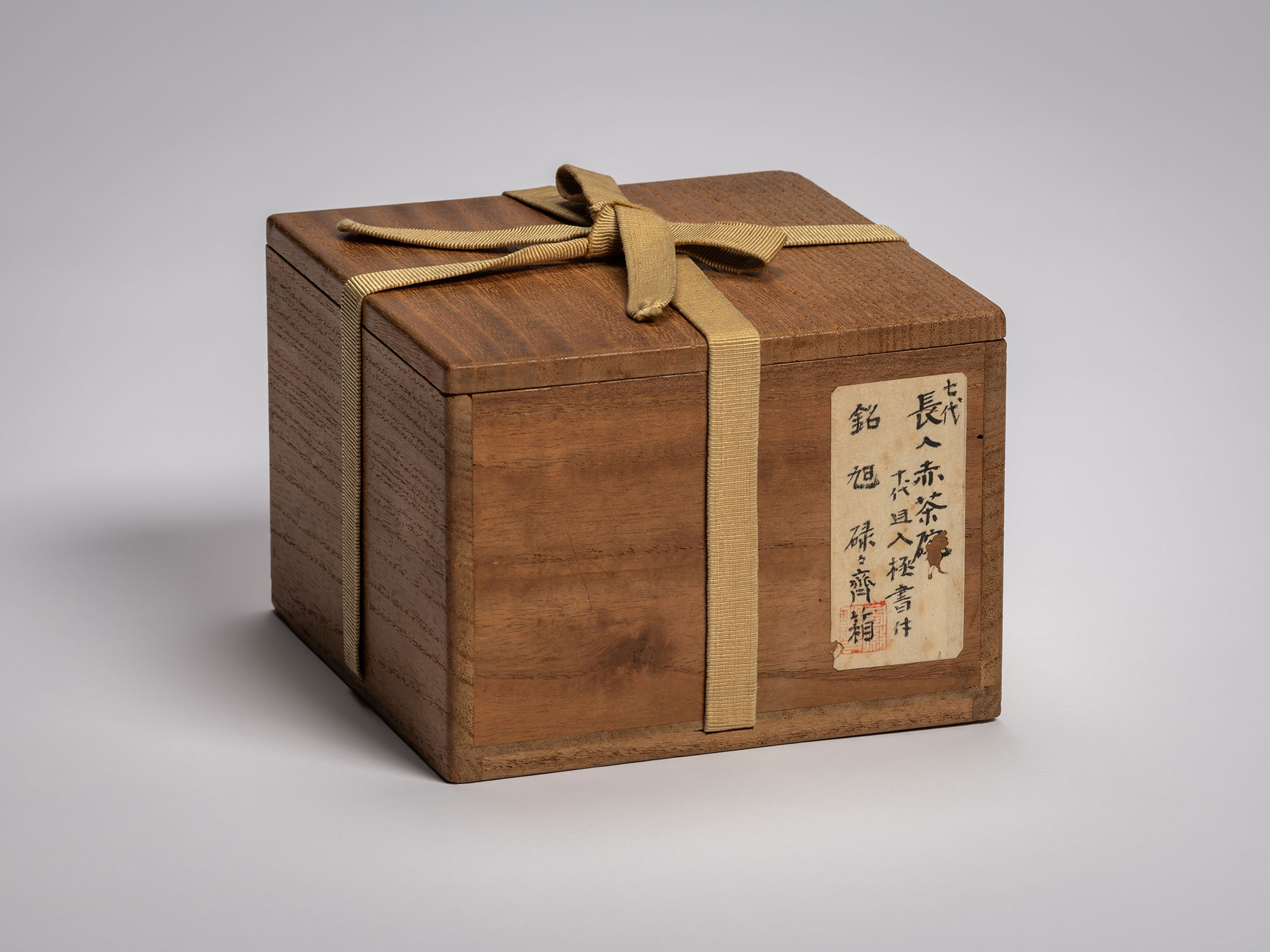 Exterior view of a dark-toned wooden inner tomobako for the Asahi tea bowl, featuring an aged patina...