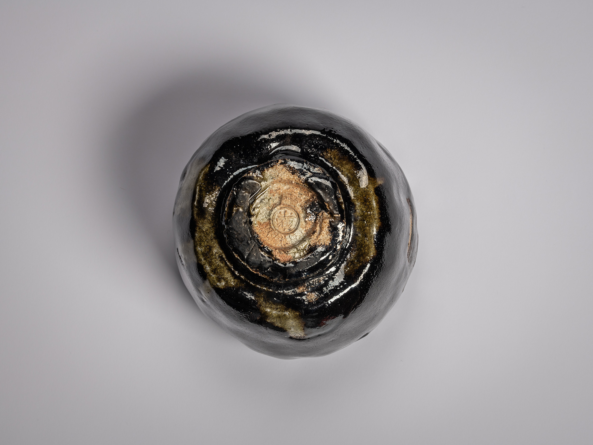 Foot (kōdai) of a Black Raku tea bowl by Raku XV, showing an unglazed clay base with the artist’s...