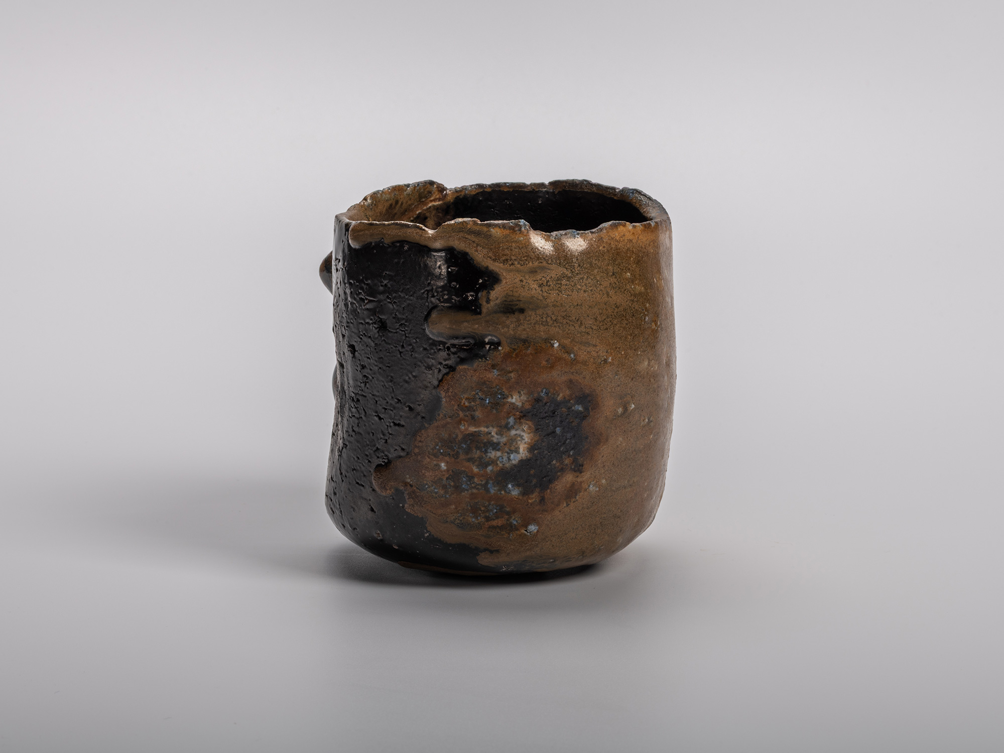 Black tea bowl by Kakurezaki Ryūichi, featuring a sculptural cylindrical form with an irregular...