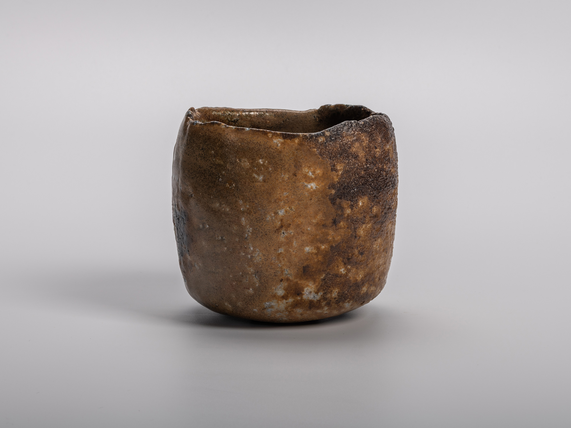Black tea bowl by Kakurezaki Ryūichi with a compact cylindrical form and irregular rim, featuring...