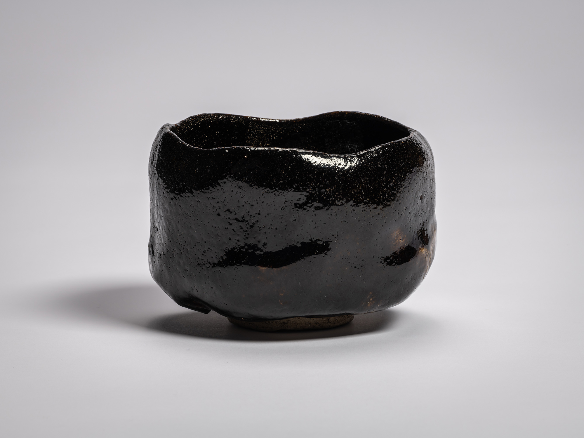 Profile view of the authentic black Raku tea bowl named Chitose (A Thousand Years) by Raku XI (Keinyū)....