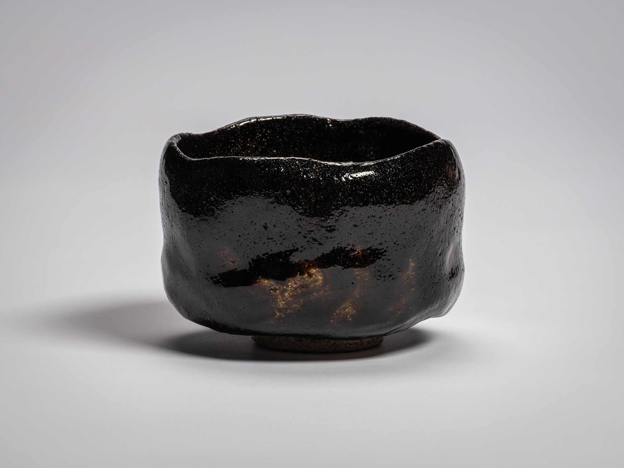 A profile view of the authentic, lustrous black Raku tea bowl named Chitose (A Thousand Years),...