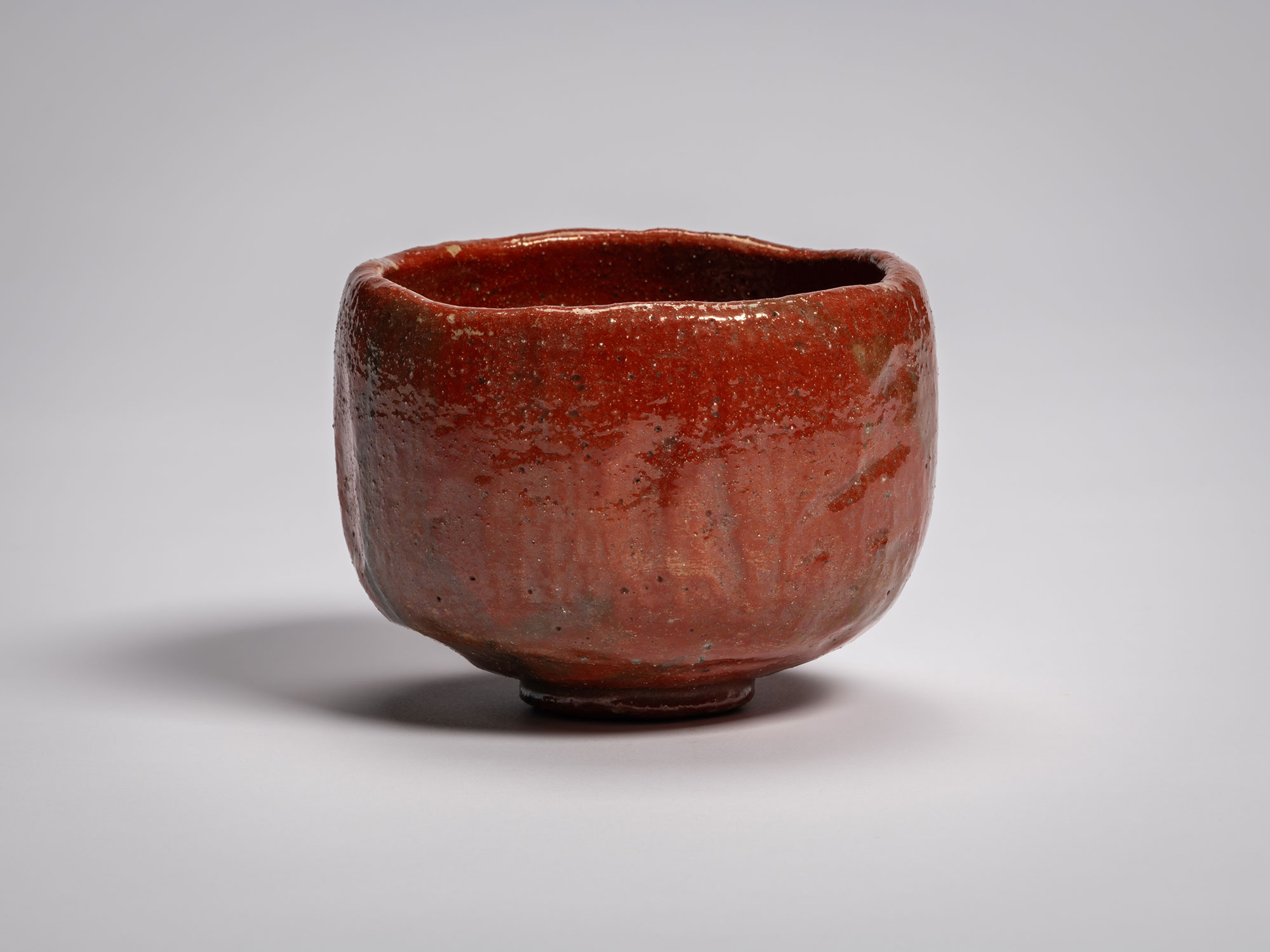 Red Raku tea bowl Daiyūhō (Great-Peak) Raku IX, with a softly rounded form, irregular rim, and...