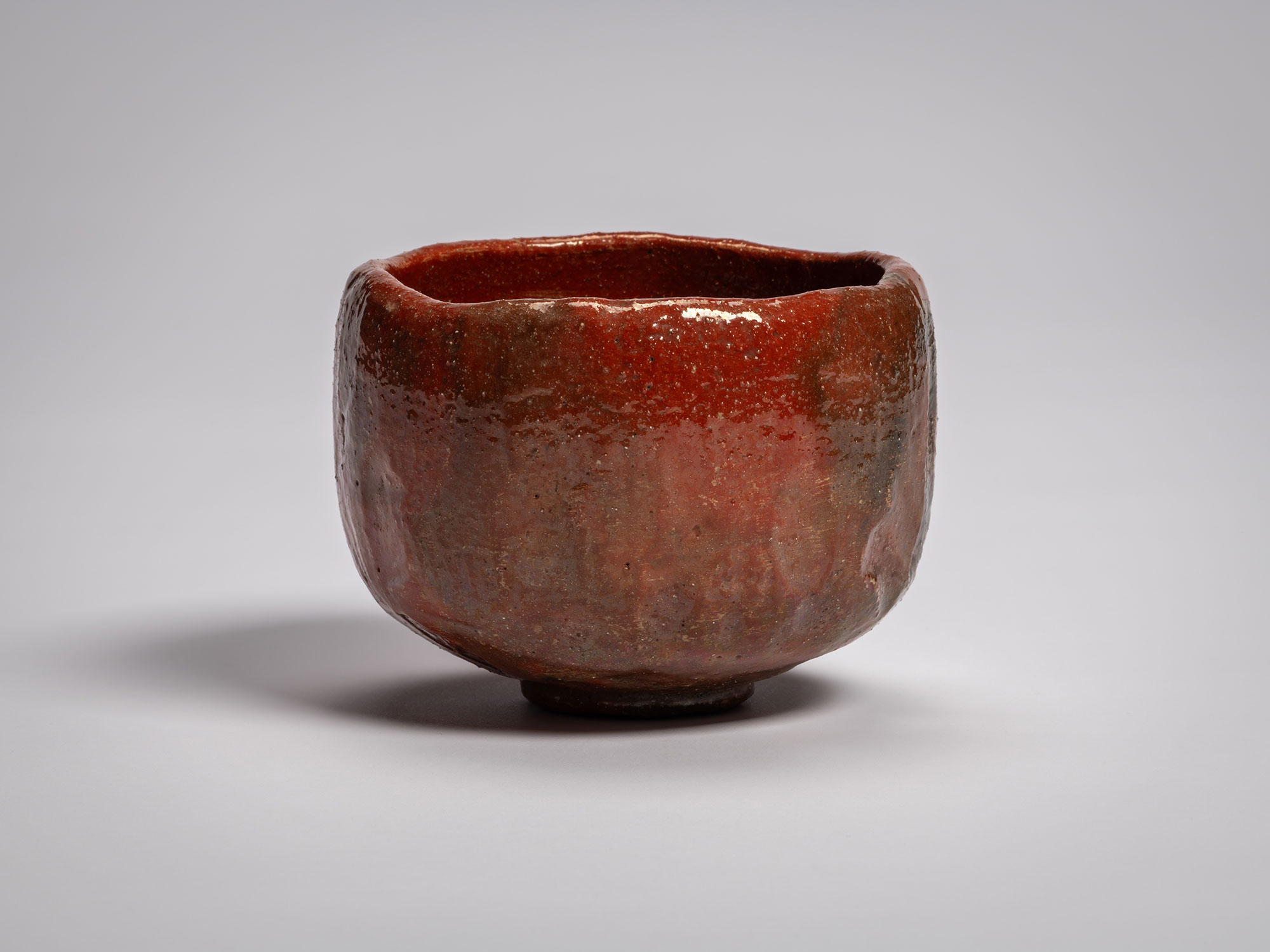 Red Raku tea bowl Daiyūhō (Great-Peak) Raku IX, with a softly rounded form, irregular rim, and...