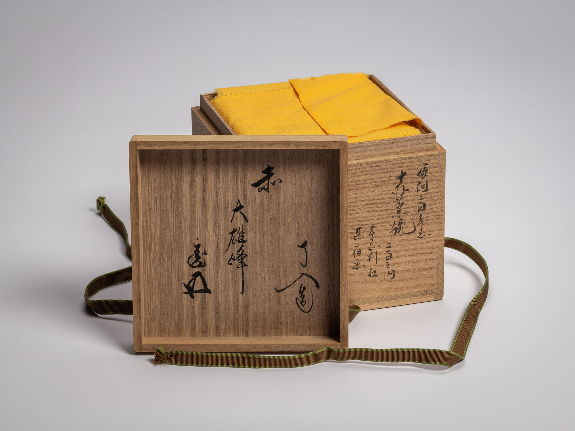 An open traditional Japanese paulownia wood tea bowl box (tomobako) with the lid placed in the...
