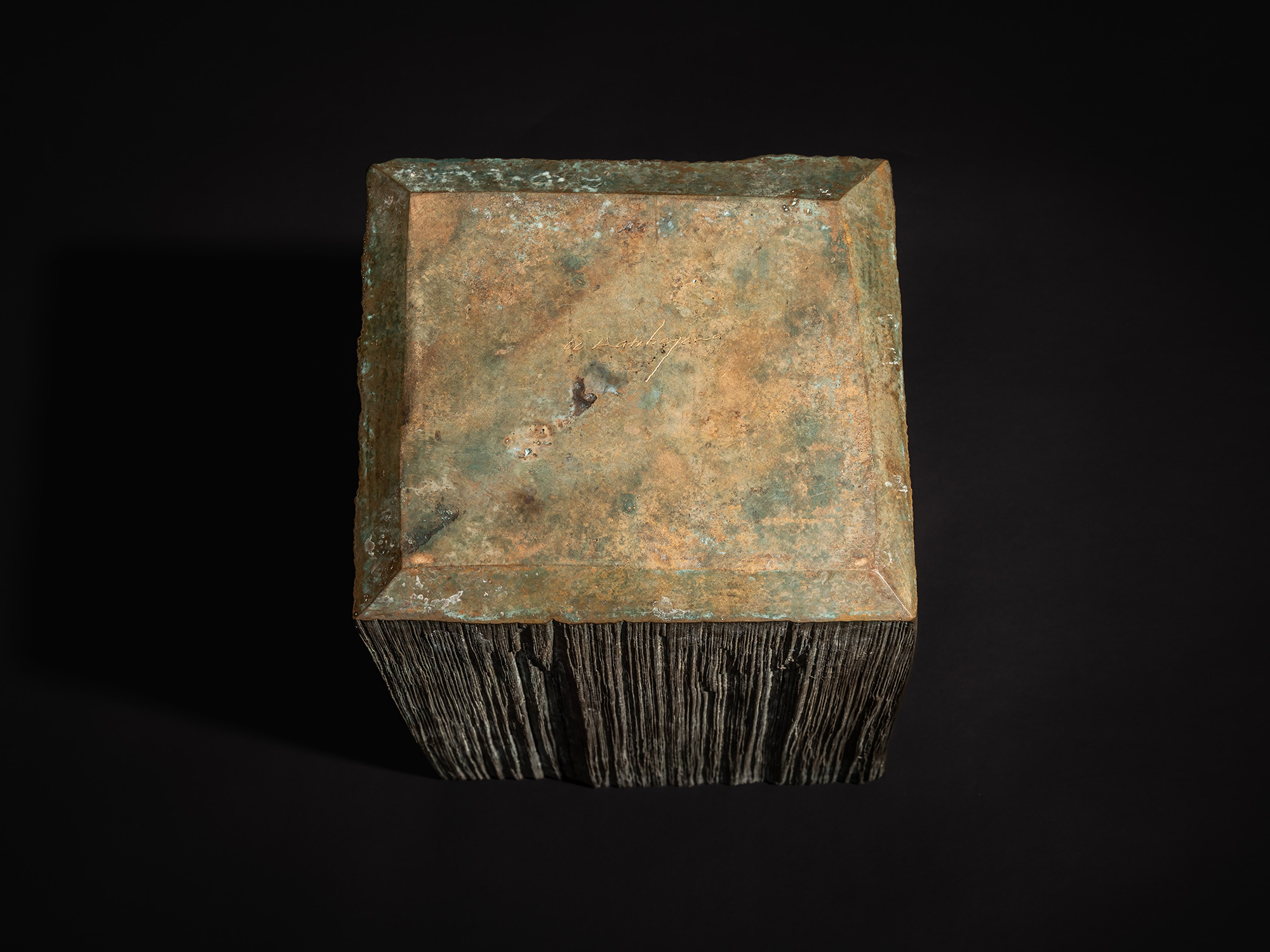 Bottom view of the bronze box from Green Expression by Koji Hatakeyama, showing a square base with...