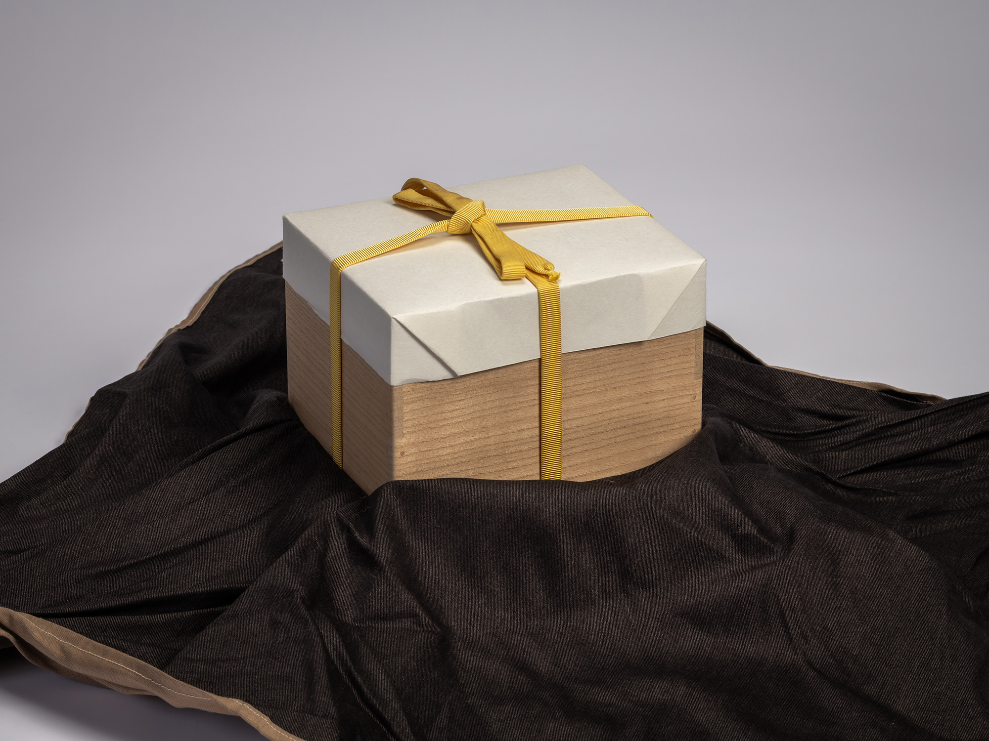 Wooden artist box containing the tea bowl Gyō by Raku XV (Jikinyū), tied with a yellow cord and...