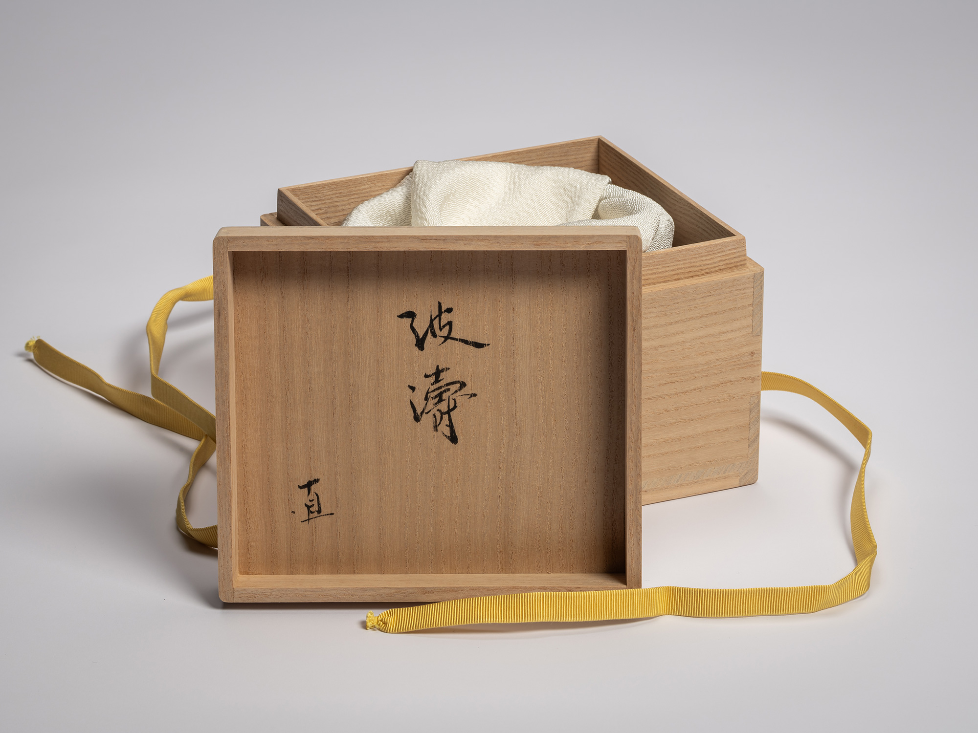 Paulownia wood box lid interior for a tea bowl by Raku XV, inscribed in black calligraphy with...