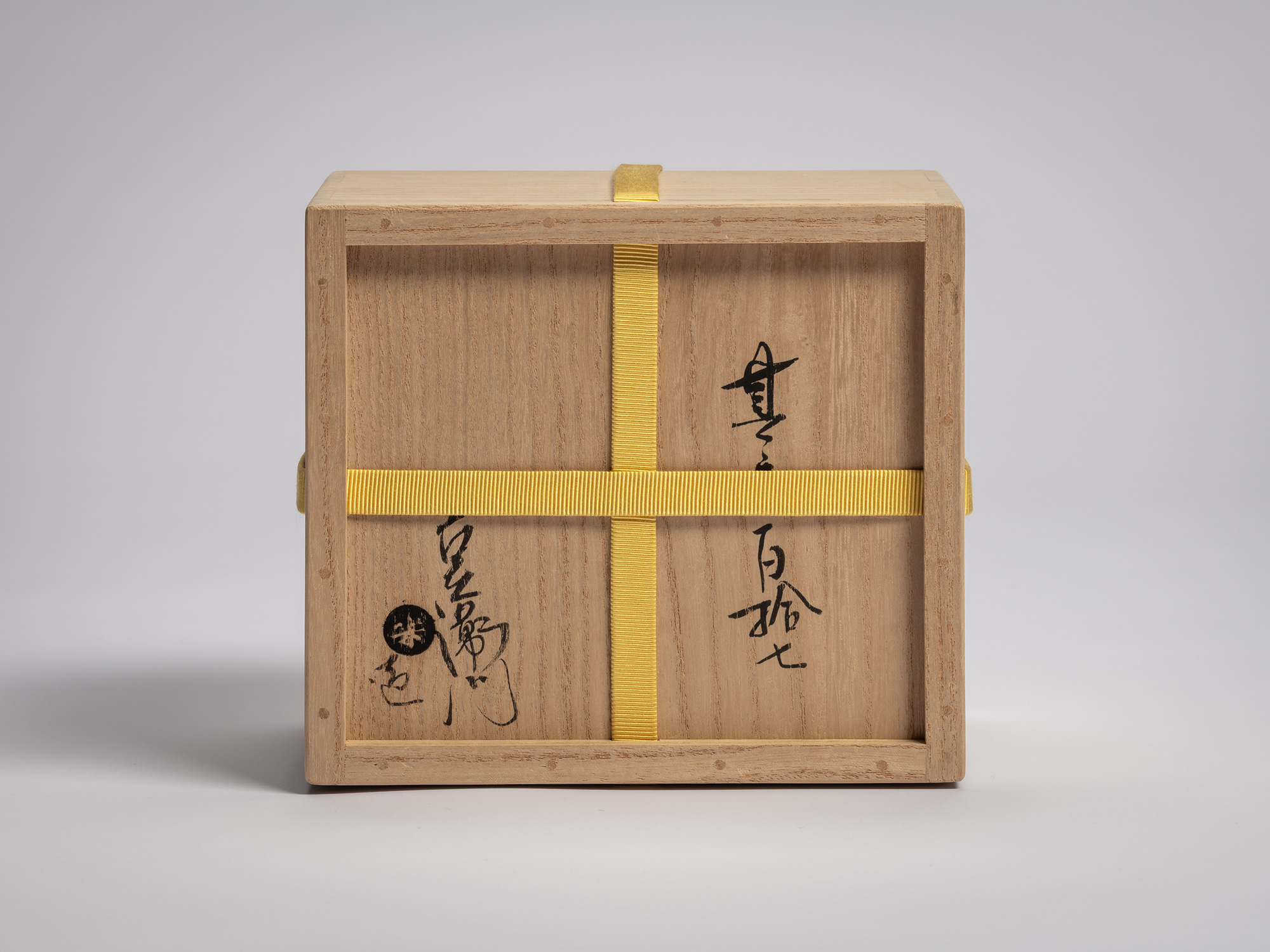 Interior underside of the paulownia wood storage box displaying handwritten inscriptions and the...