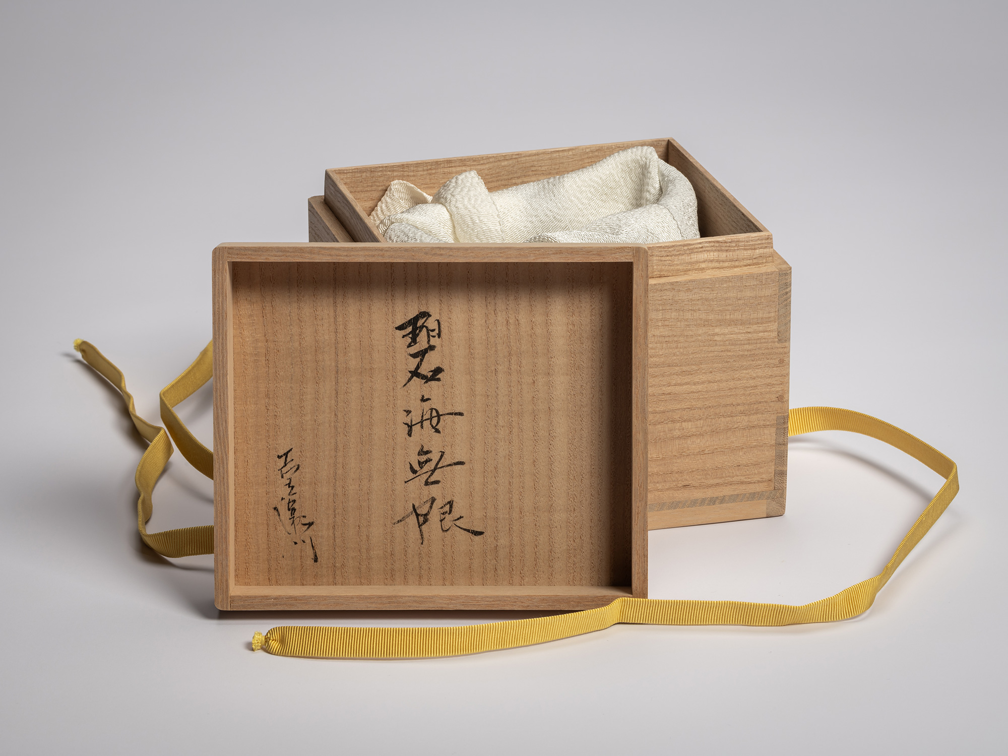 Interior of the paulownia wood tomobako lid inscribed in black ink with the title Hekikai Mugen...